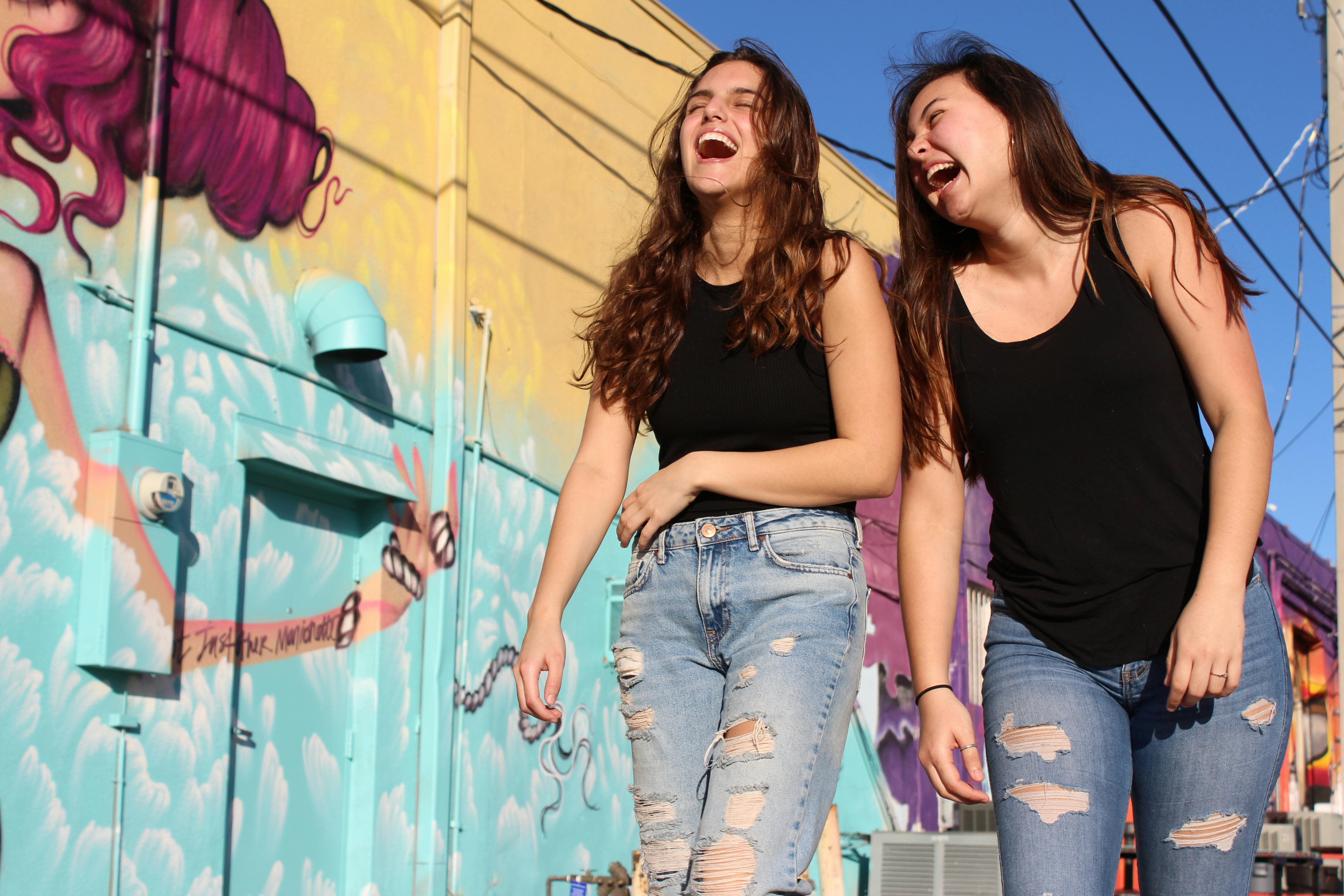 Dos mujeres jóvenes caminando y riendo | Foto: Pexels