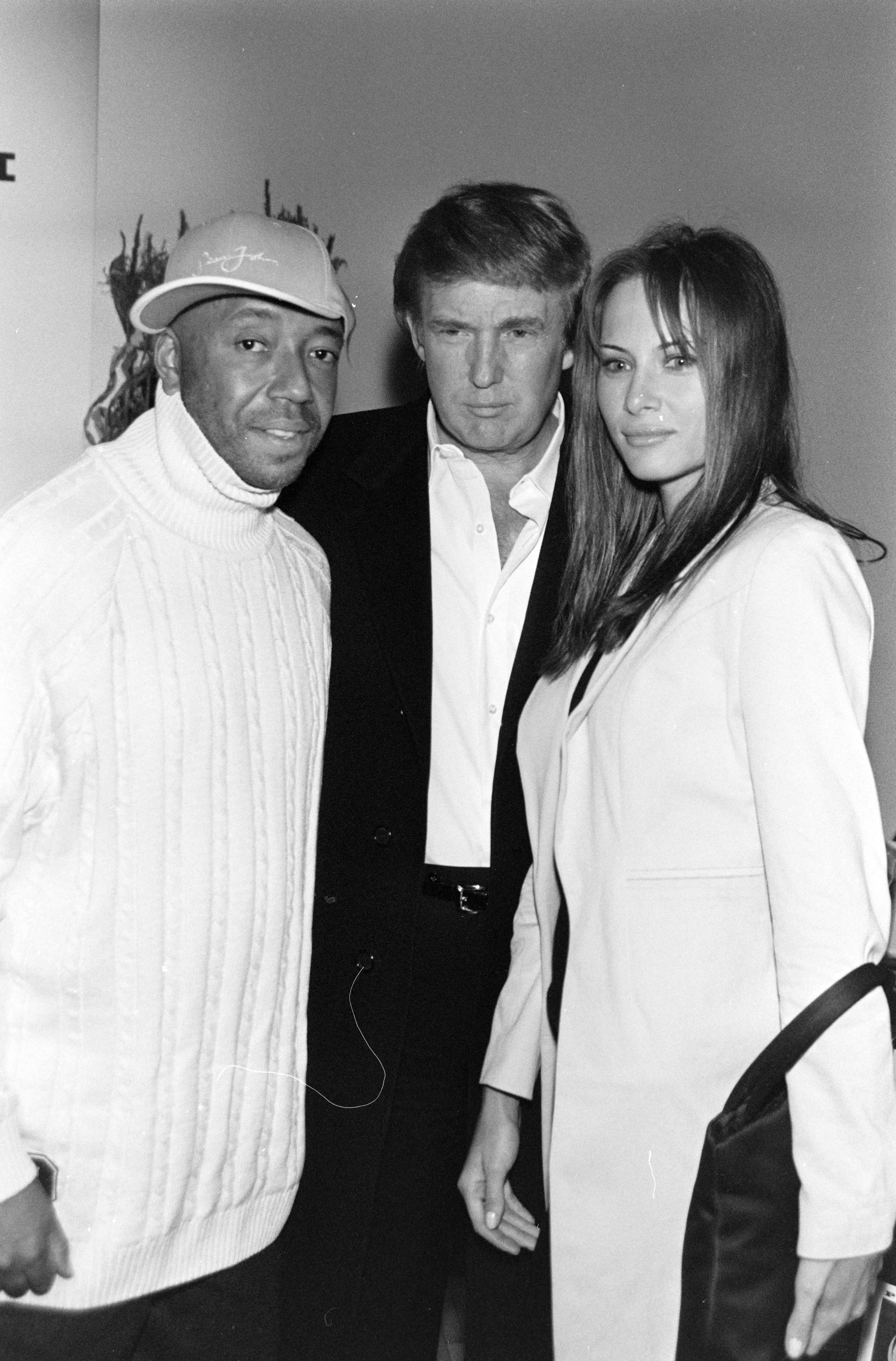 Russell Simmons con Donald y Melania Trump en el desfile de moda Phat Farm Primavera 1998 Ready to Wear. | Fuente: Getty Images