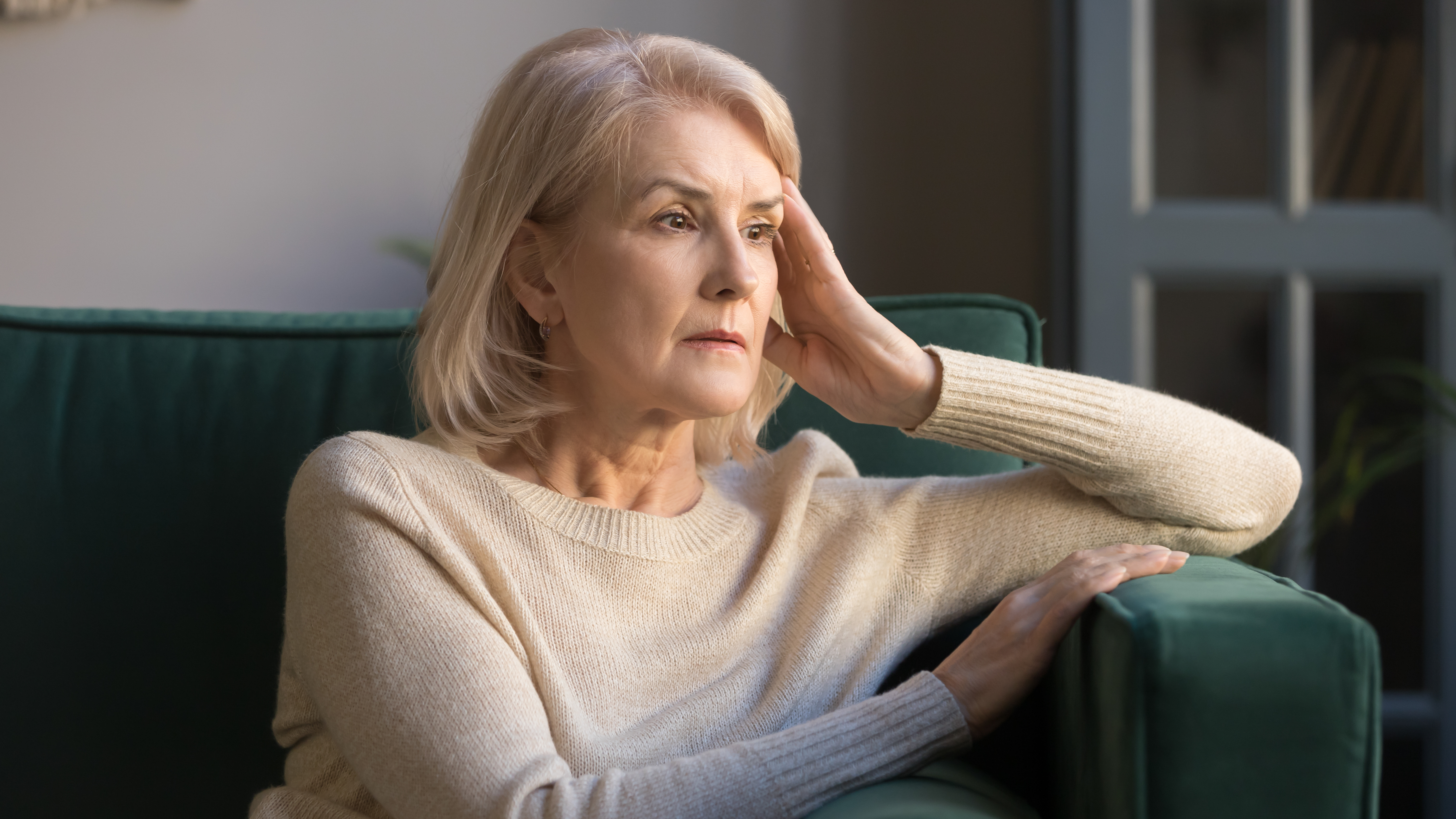 Una anciana alterada sentada en un sofá | Foto: Shutterstock