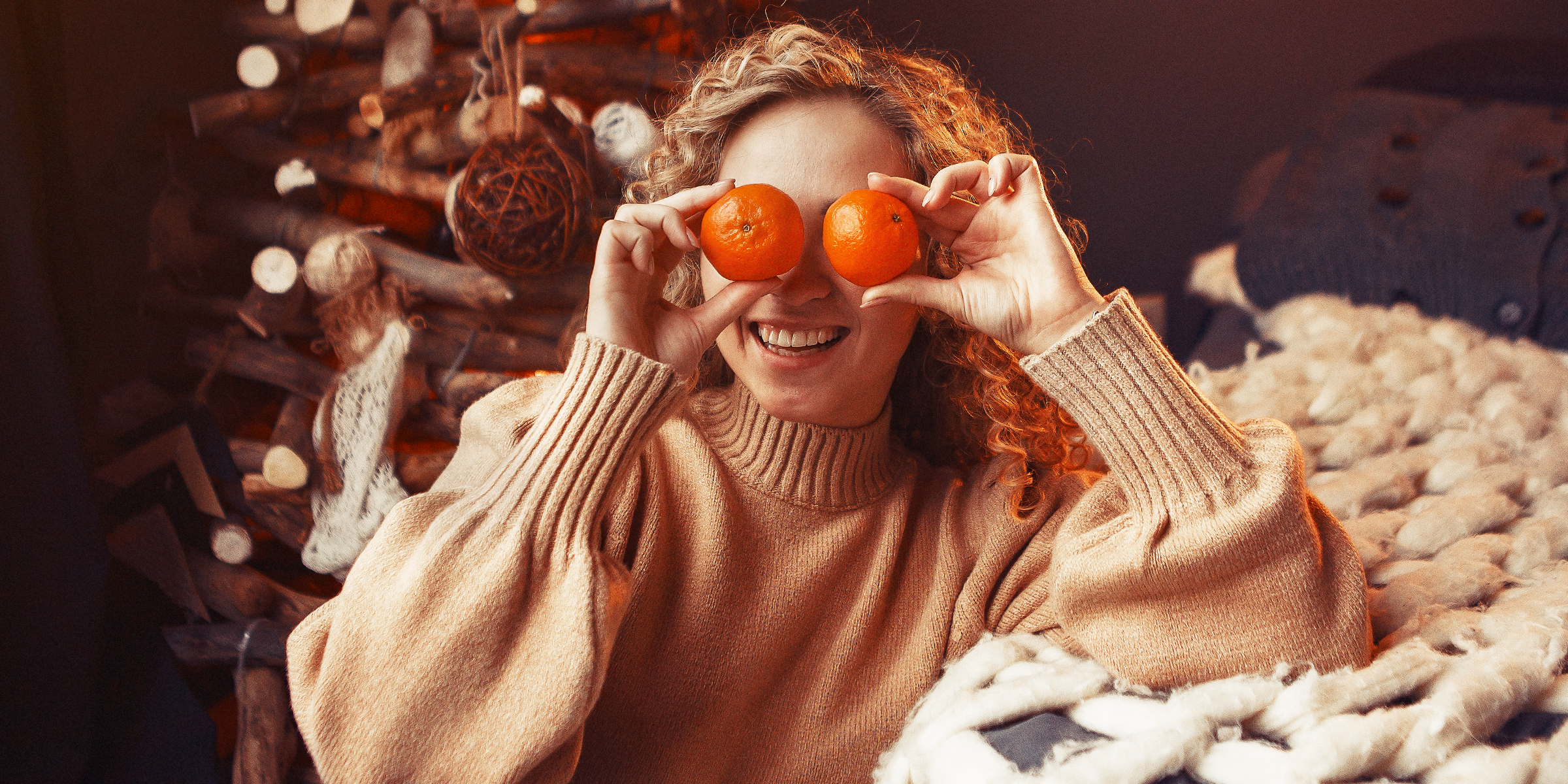 Una mujer sosteniendo naranjas delante de sus ojos | Fuente: Freepik.com/prostooleh