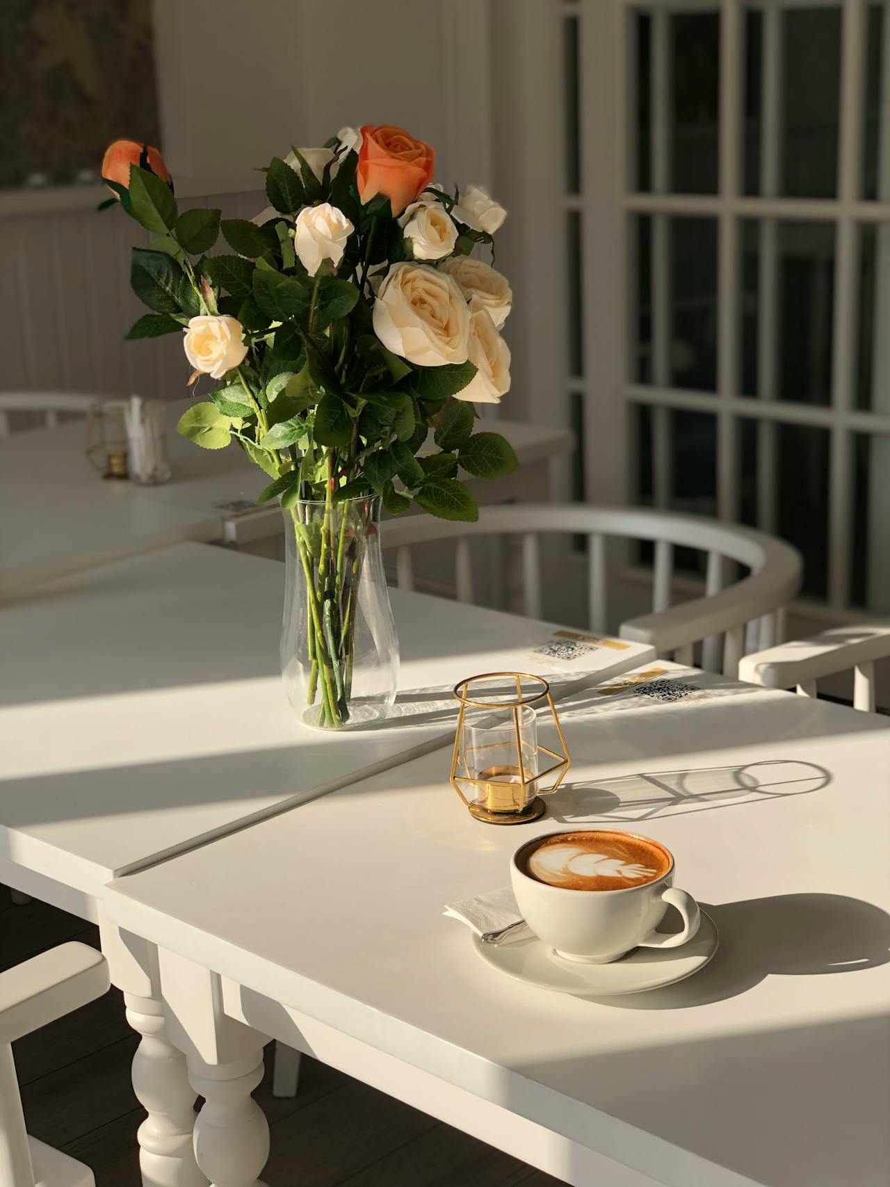 Un jarrón de flores y una taza de café sobre la mesa | Fuente: Pexels