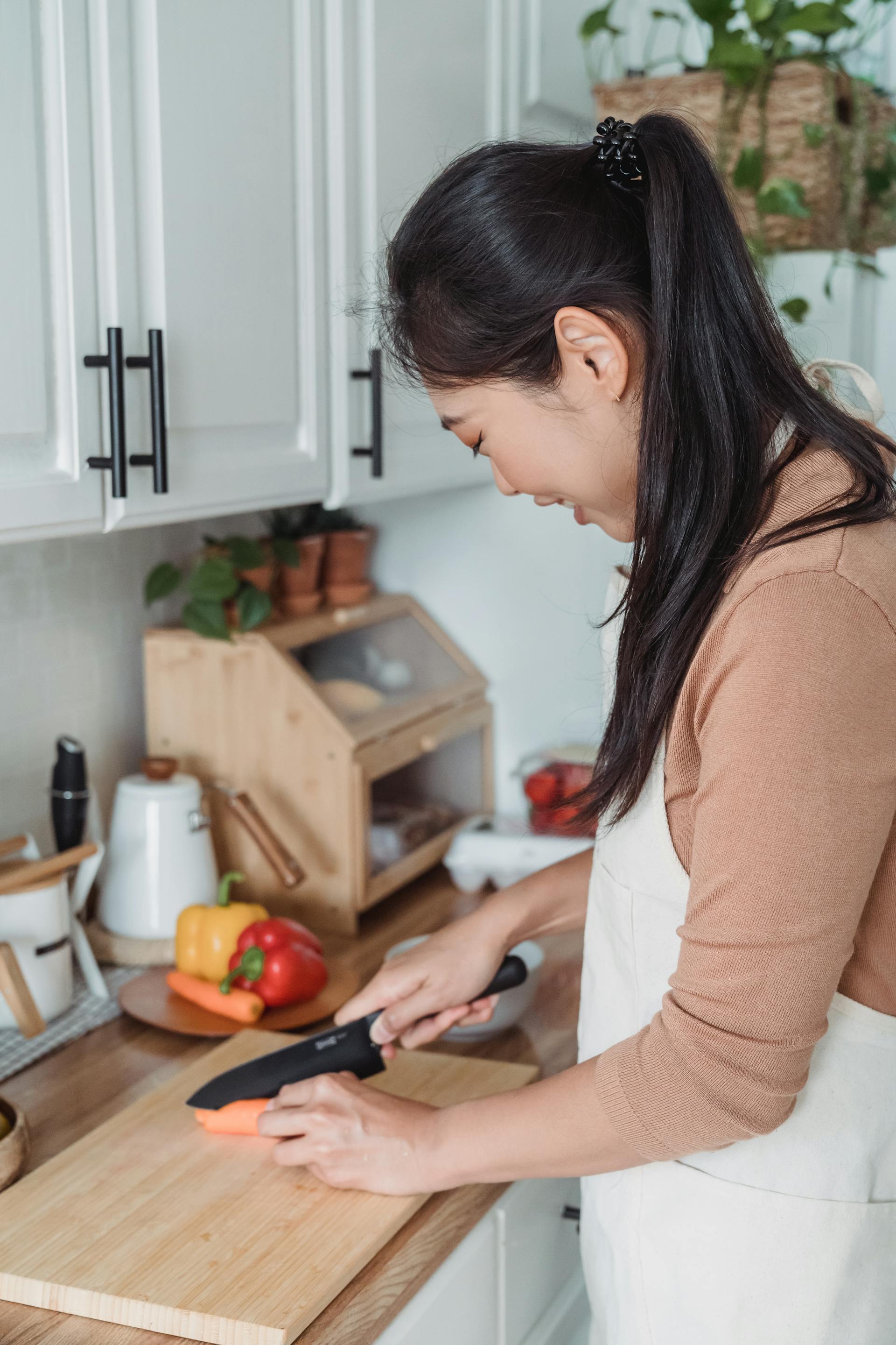 Una mujer cortando zanahorias | Fuente: Pexels