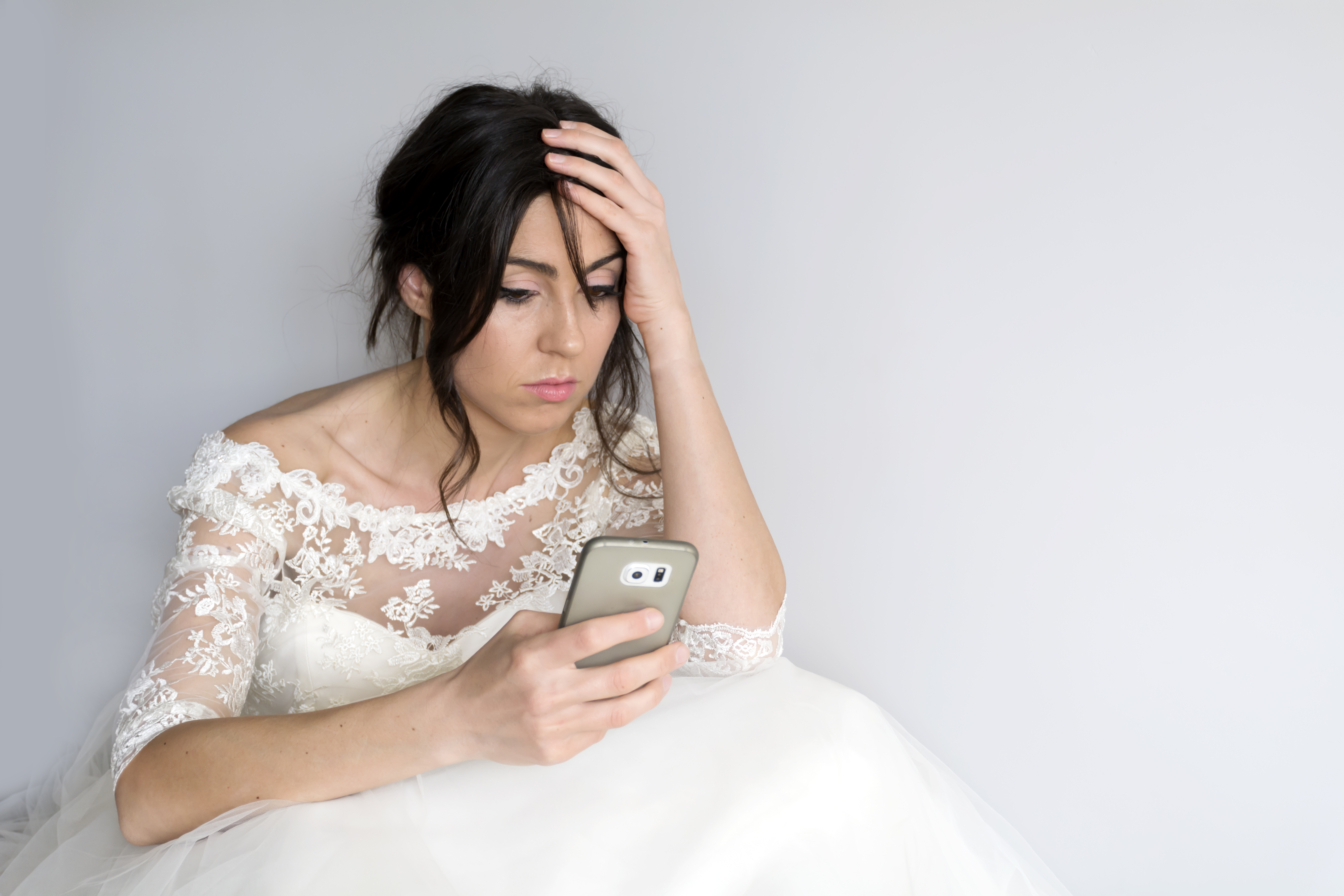 Novia triste mirando su teléfono | Foto: Getty Images
