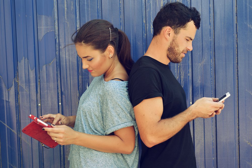 Pareja revisando sus celulares. | Foto: Shutterstock.