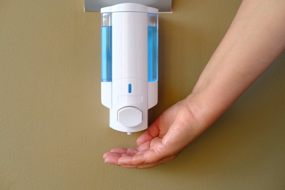 Persona lavándose las manos con dispensador automático de gel antibacterial. | Foto: Shutterstock