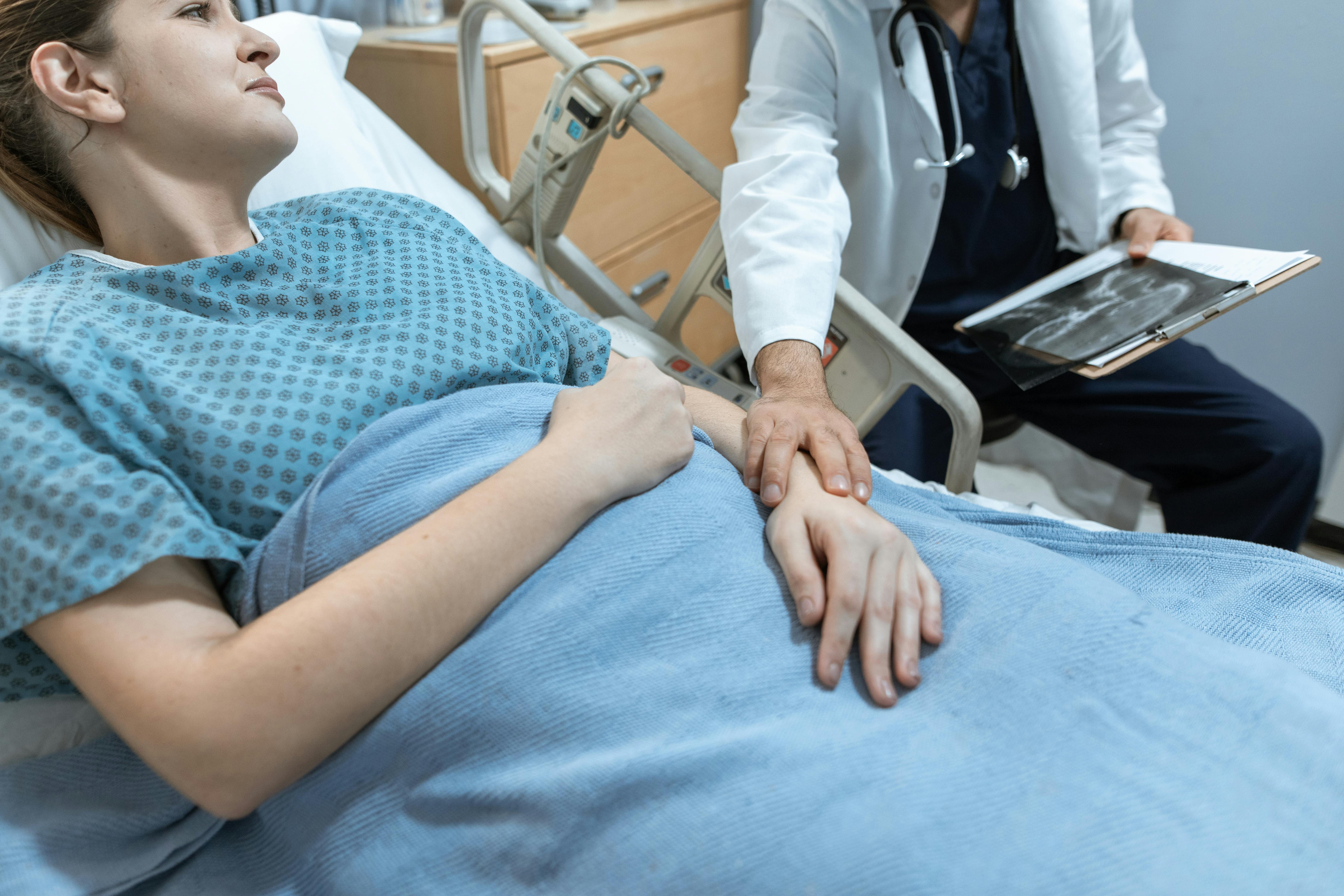 Mujer en la cama de un hospital con un médico | Foto: Pexels