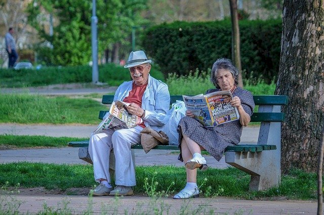 Abuelos leyendo el periódico en un parque. Fuente: Pixabay