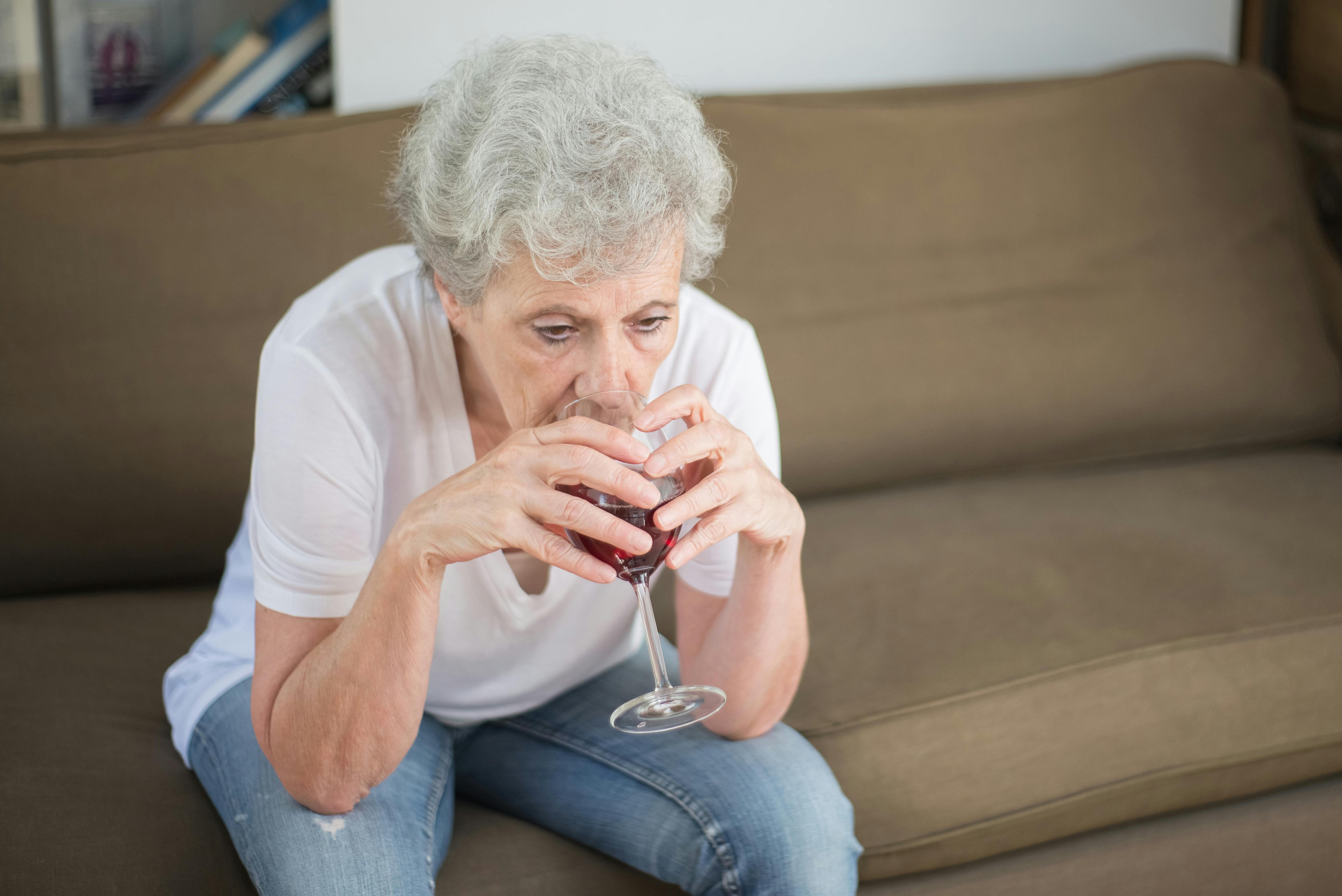 Una mujer triste bebiendo vino sola | Fuente: Pexels