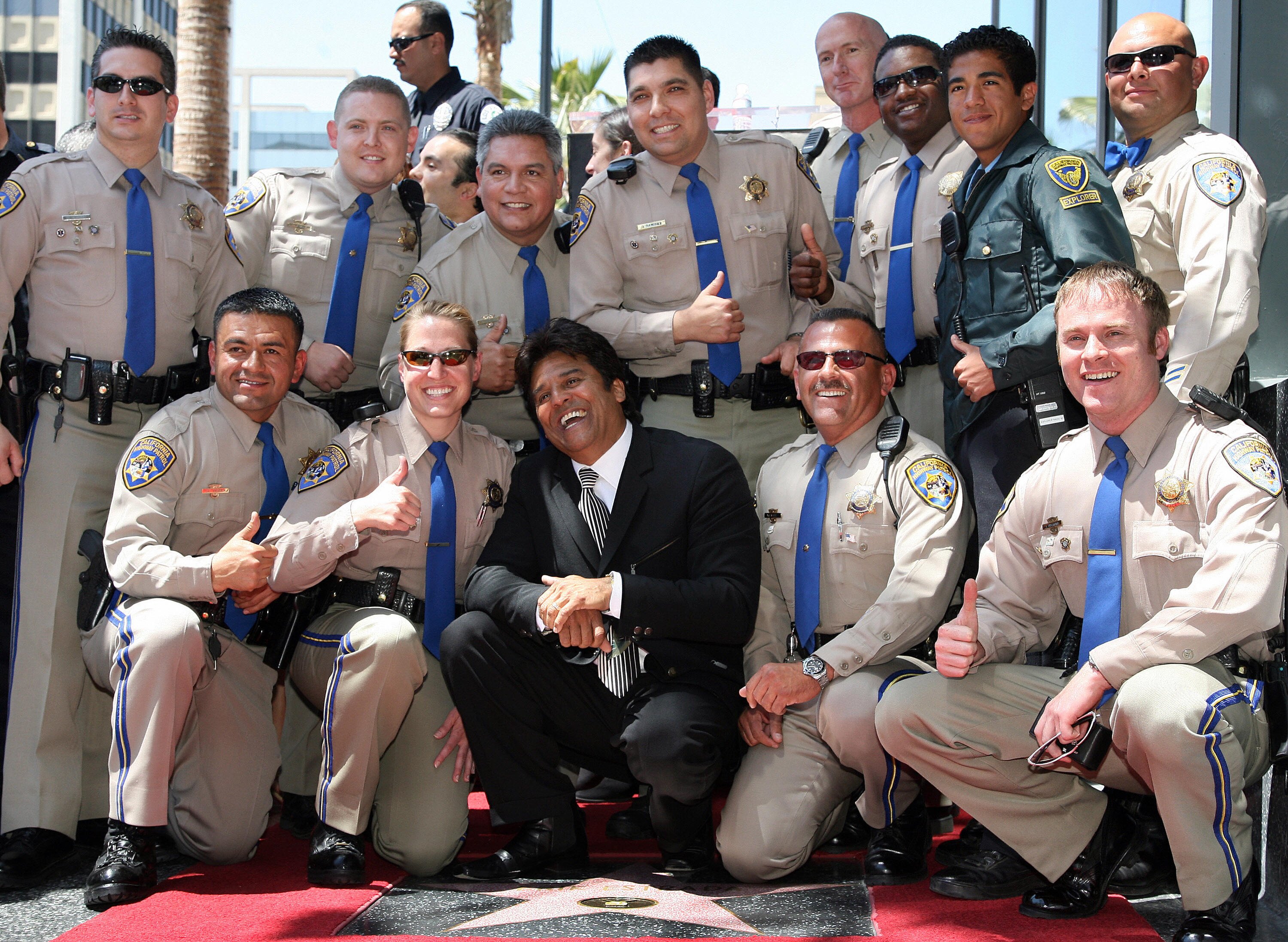 Erik Estrada con oficiales de la Patrulla de Carreteras de California en Hollywood Boulevard, el 19 de abril de 2007 en Los Ángeles, California, Estados Unidos. | Foto: Getty Images