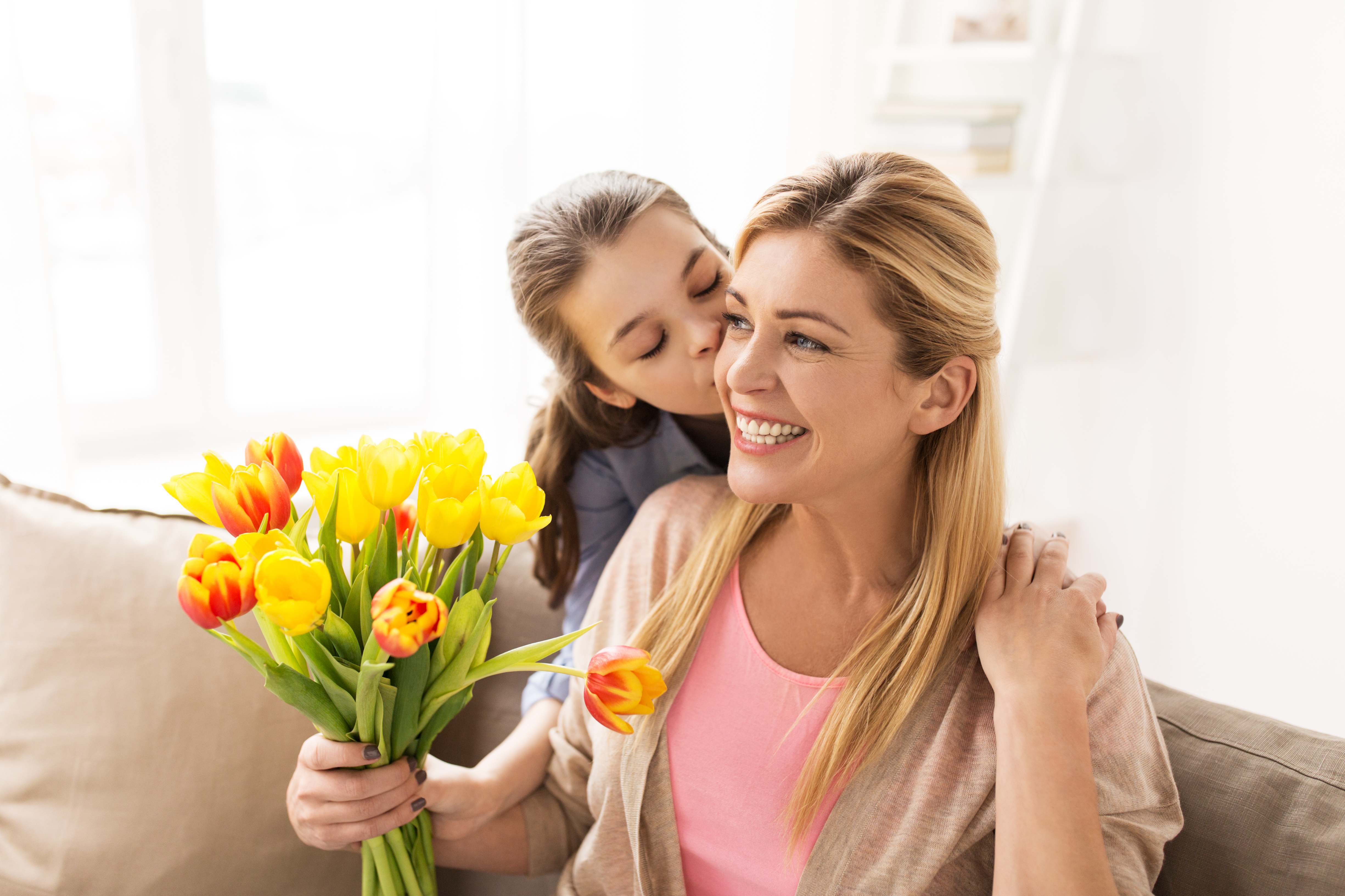 Una adolescente besa a su madre y le regala flores | Foto: Shutterstock