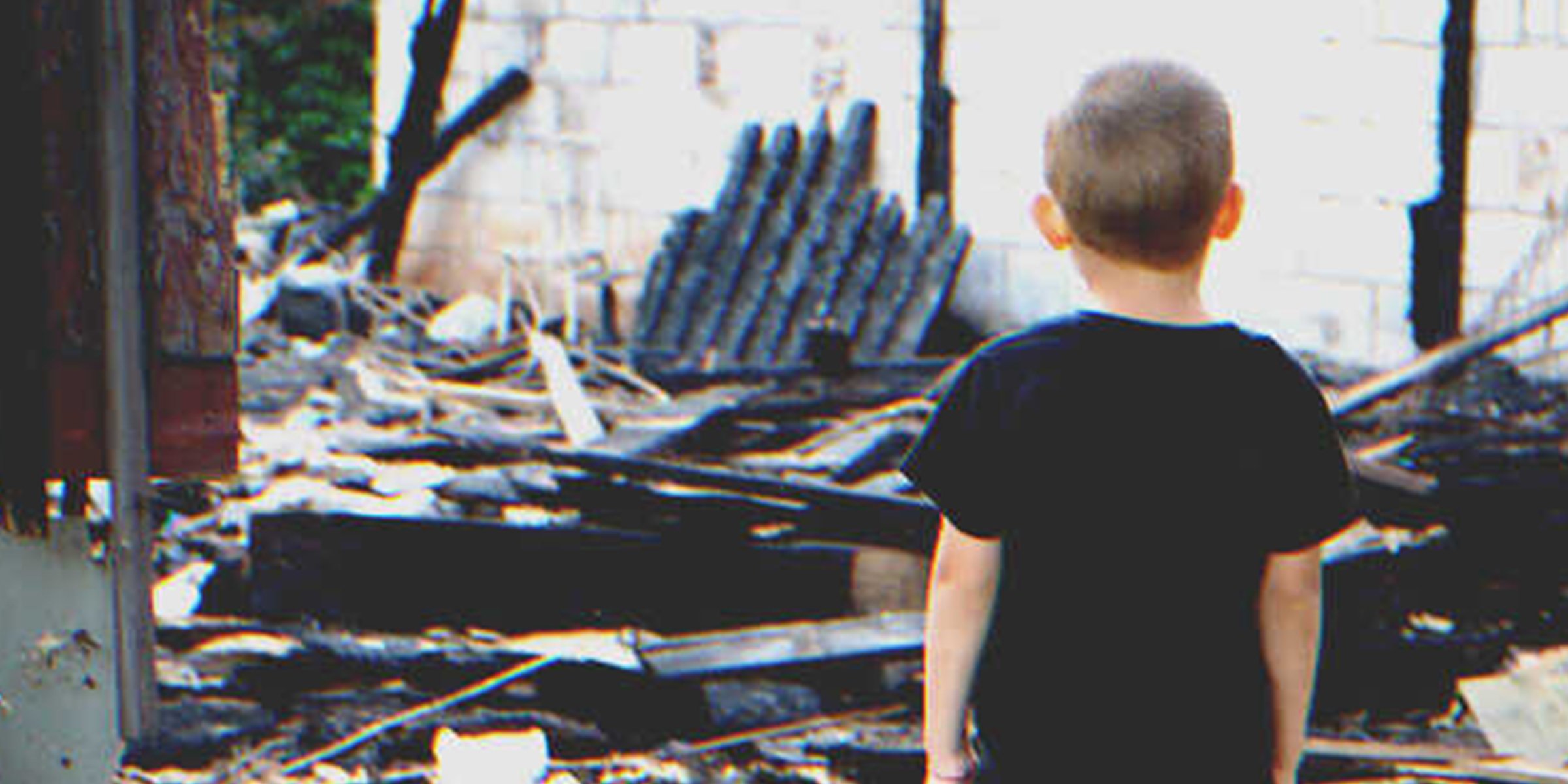 Un niño frente a una casa destrozada | Foto: Shutterstock
