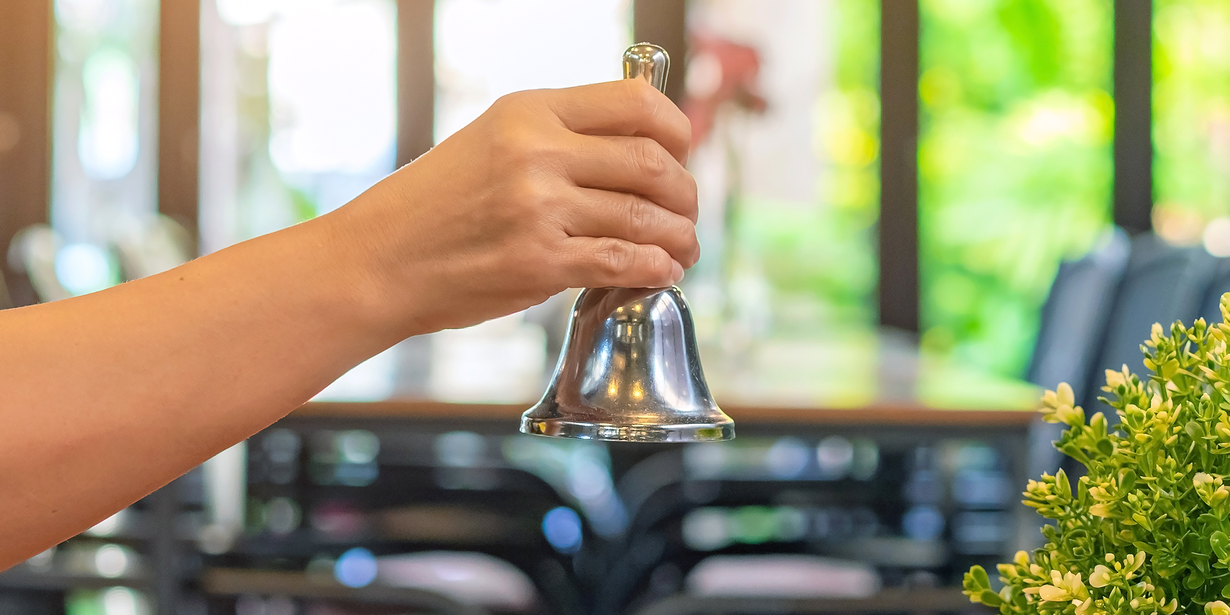 Mujer tocando la campana de servicio de un restaurante | Fuente: Shutterstock