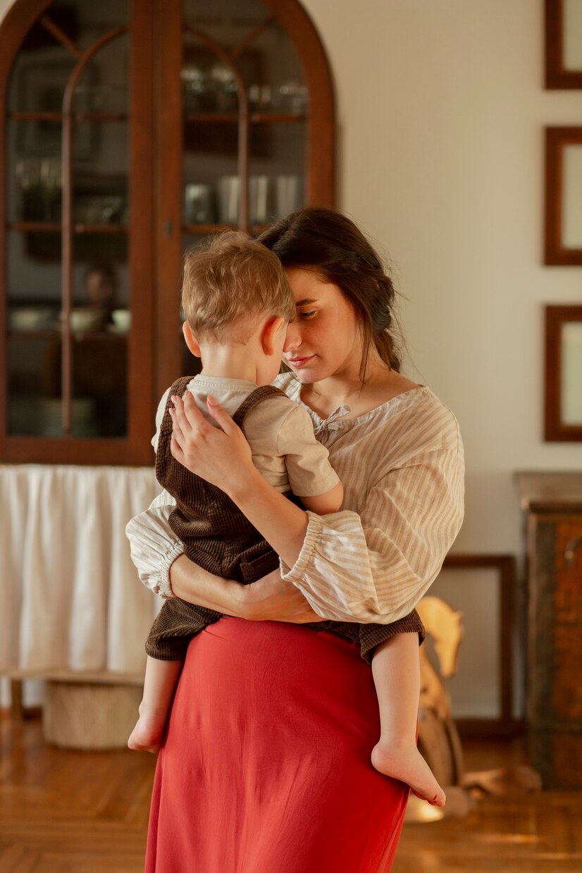 Una mujer llevando a un niño pequeño | Fuente: Freepik