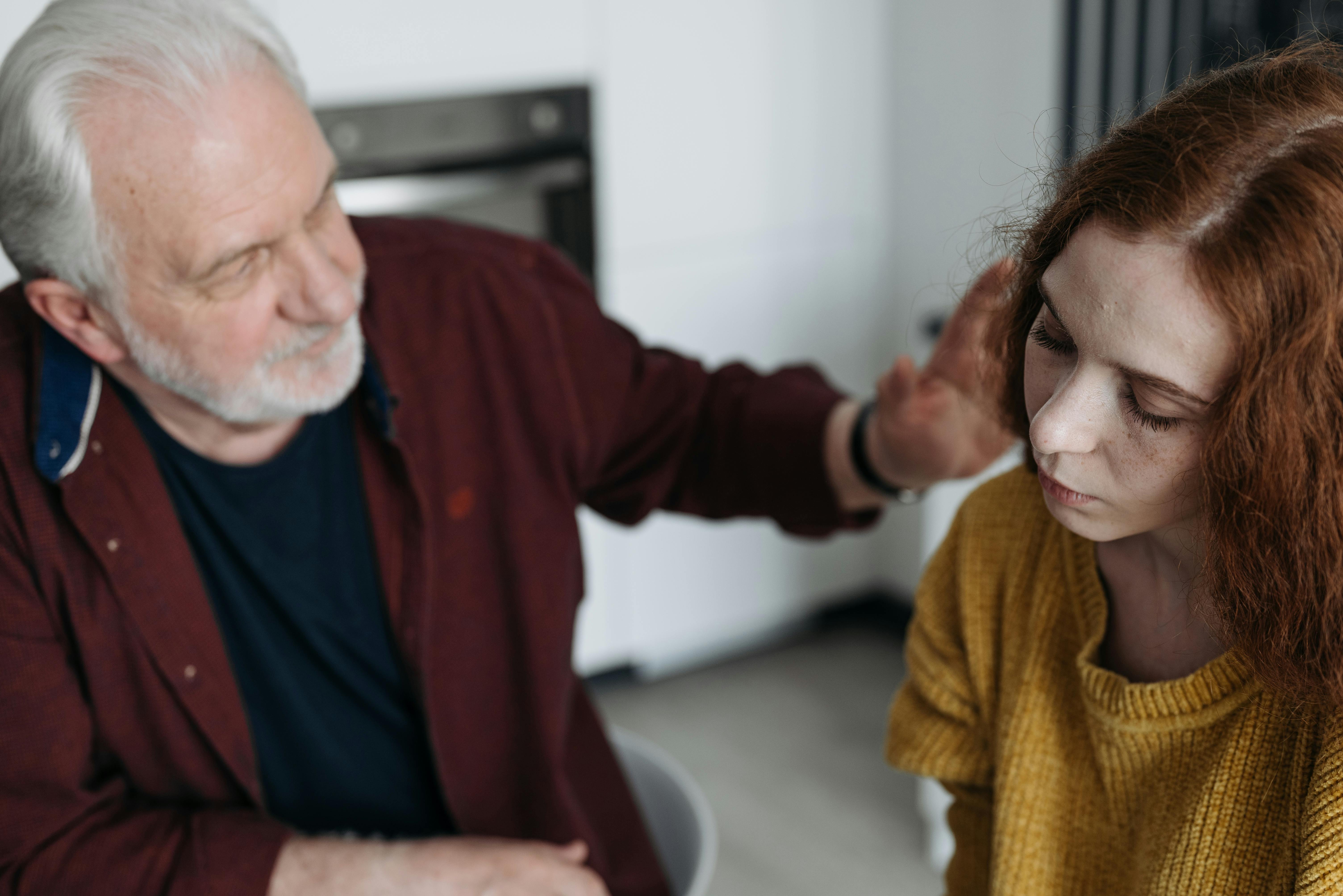 Un hombre mayor consolando a una joven triste | Foto: Pexels