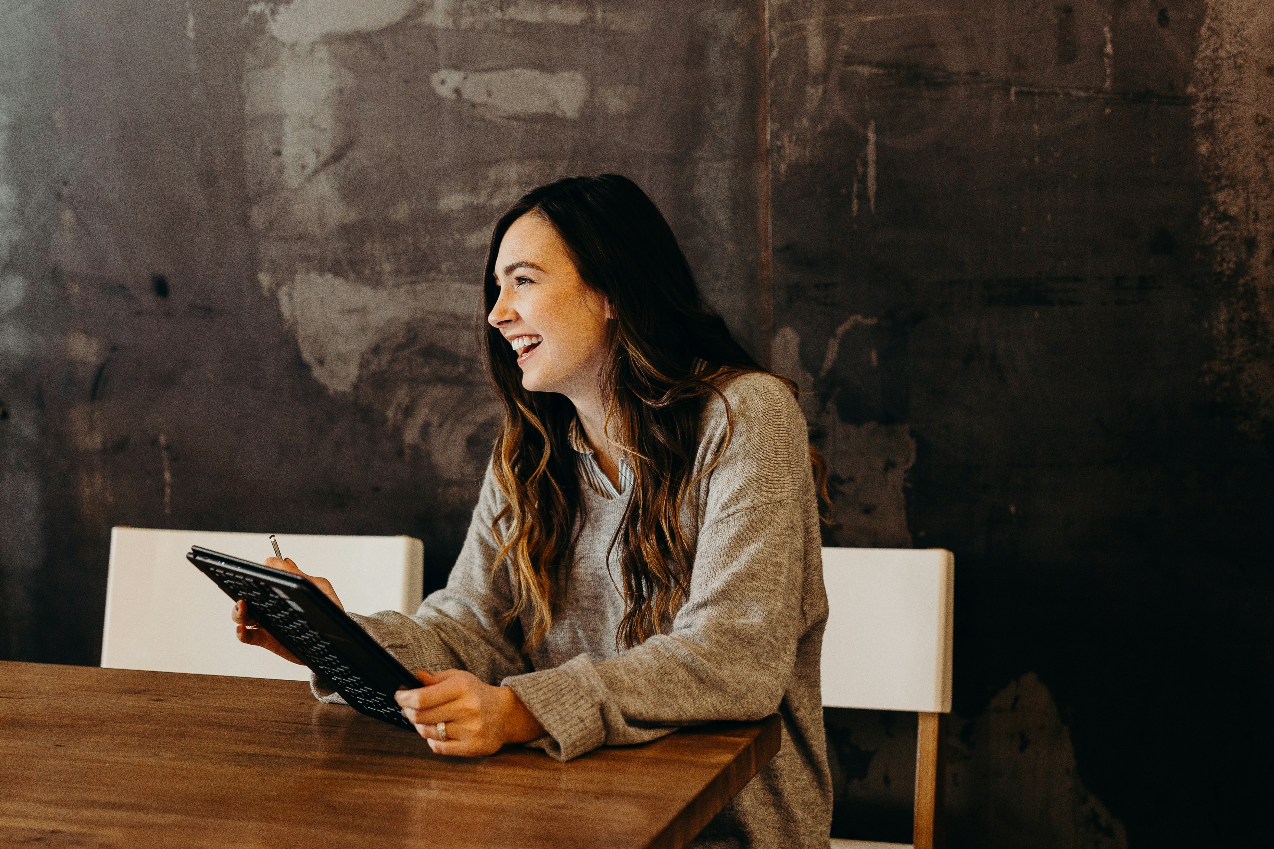 Una mujer riendo en su lugar de trabajo | Fuente: Unsplash