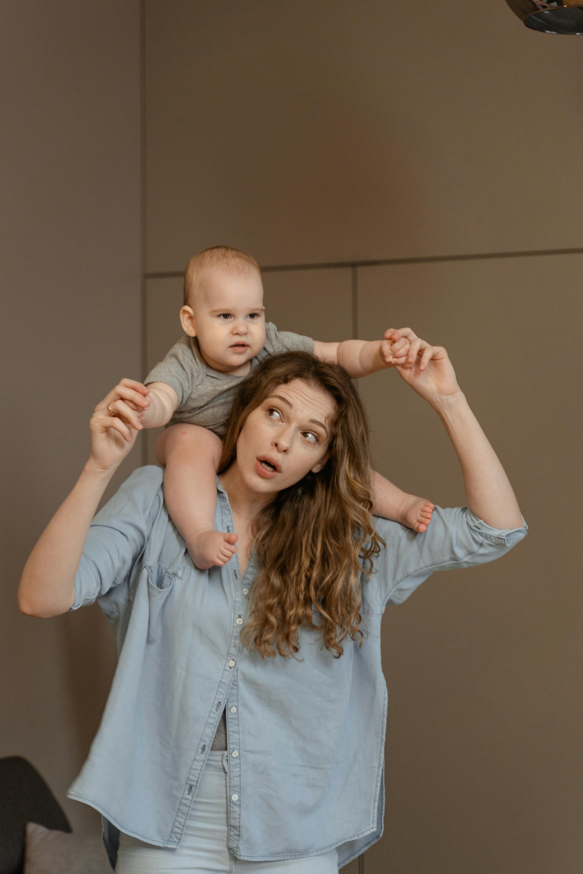 Una mujer lleva a un niño pequeño al hombro | Fuente: Pexels