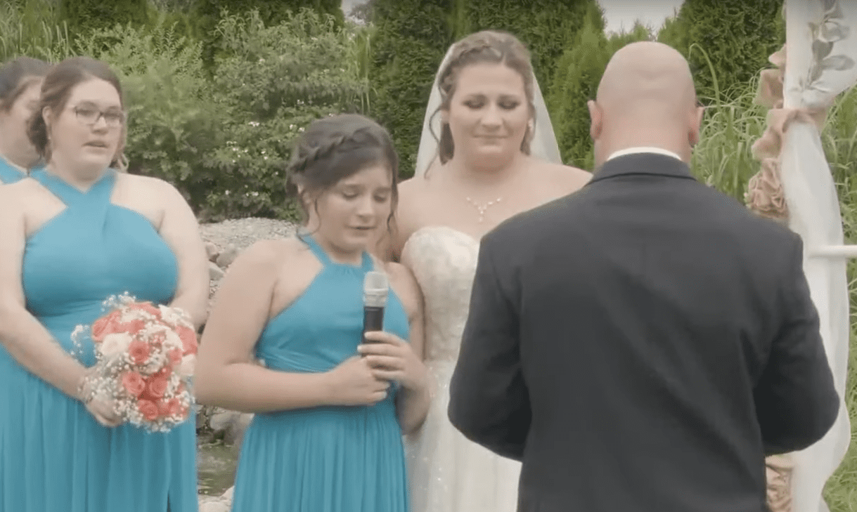 Aryanna junto a su madre en su boda con un micrófono en su mano. | Foto: youtube.com/TODAY