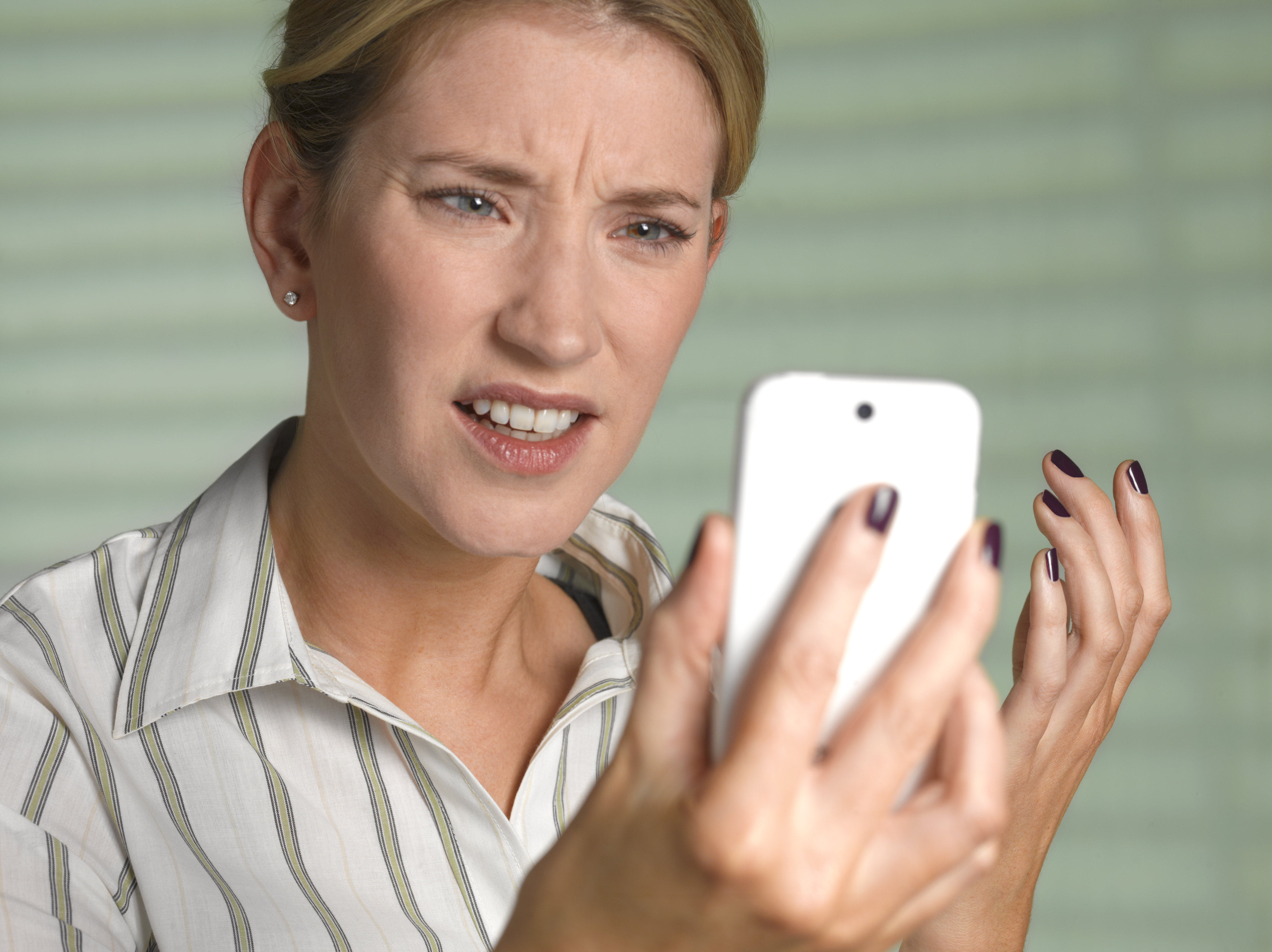 Una mujer confusa y alterada mirando un teléfono | Fuente: Getty Images