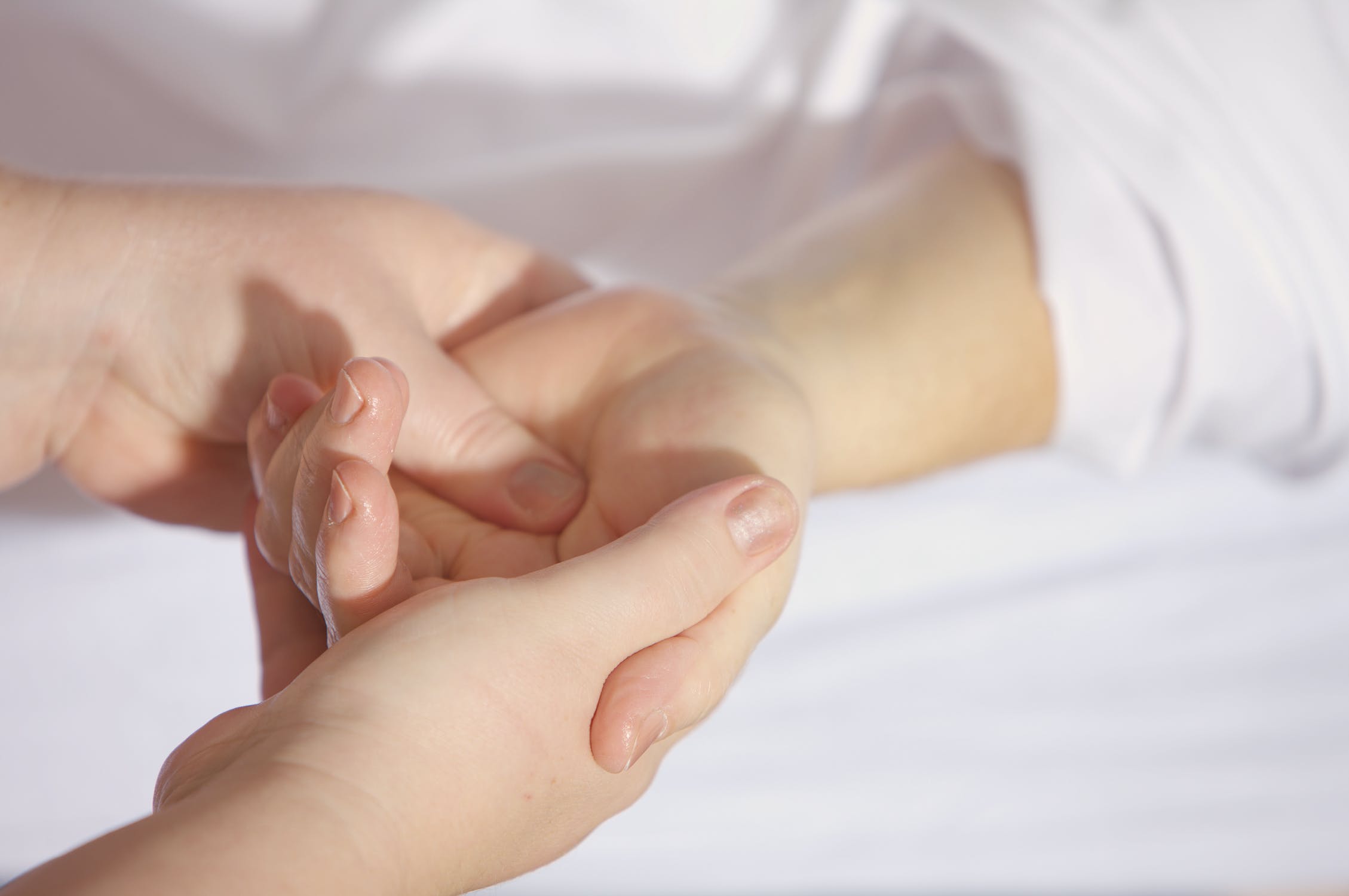 Mujer sosteniendo la mano de una persona postrada en una cama de hospital. | Foto: Pexels