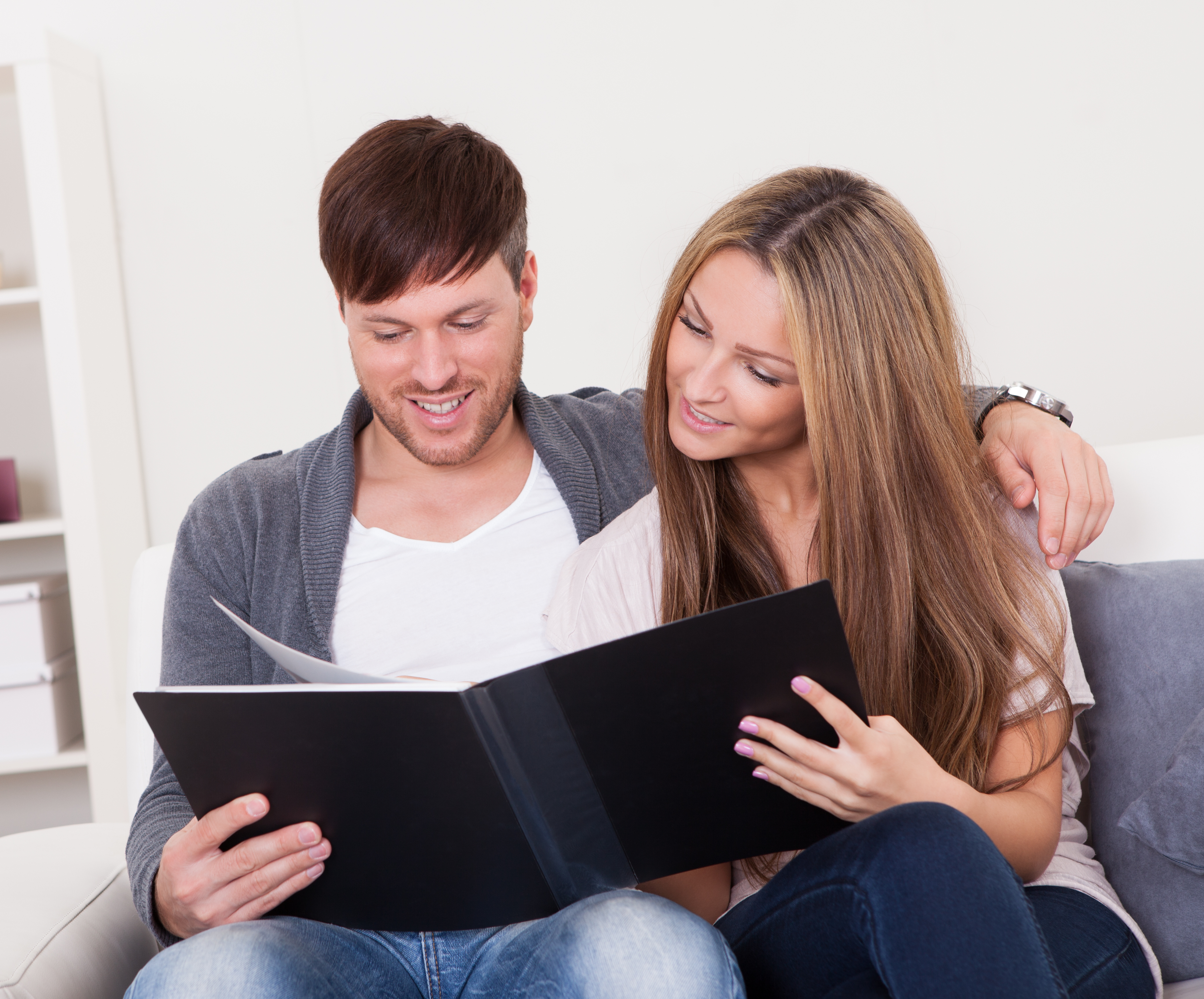 Una pareja mirando un álbum de fotos | Fuente: Shutterstock