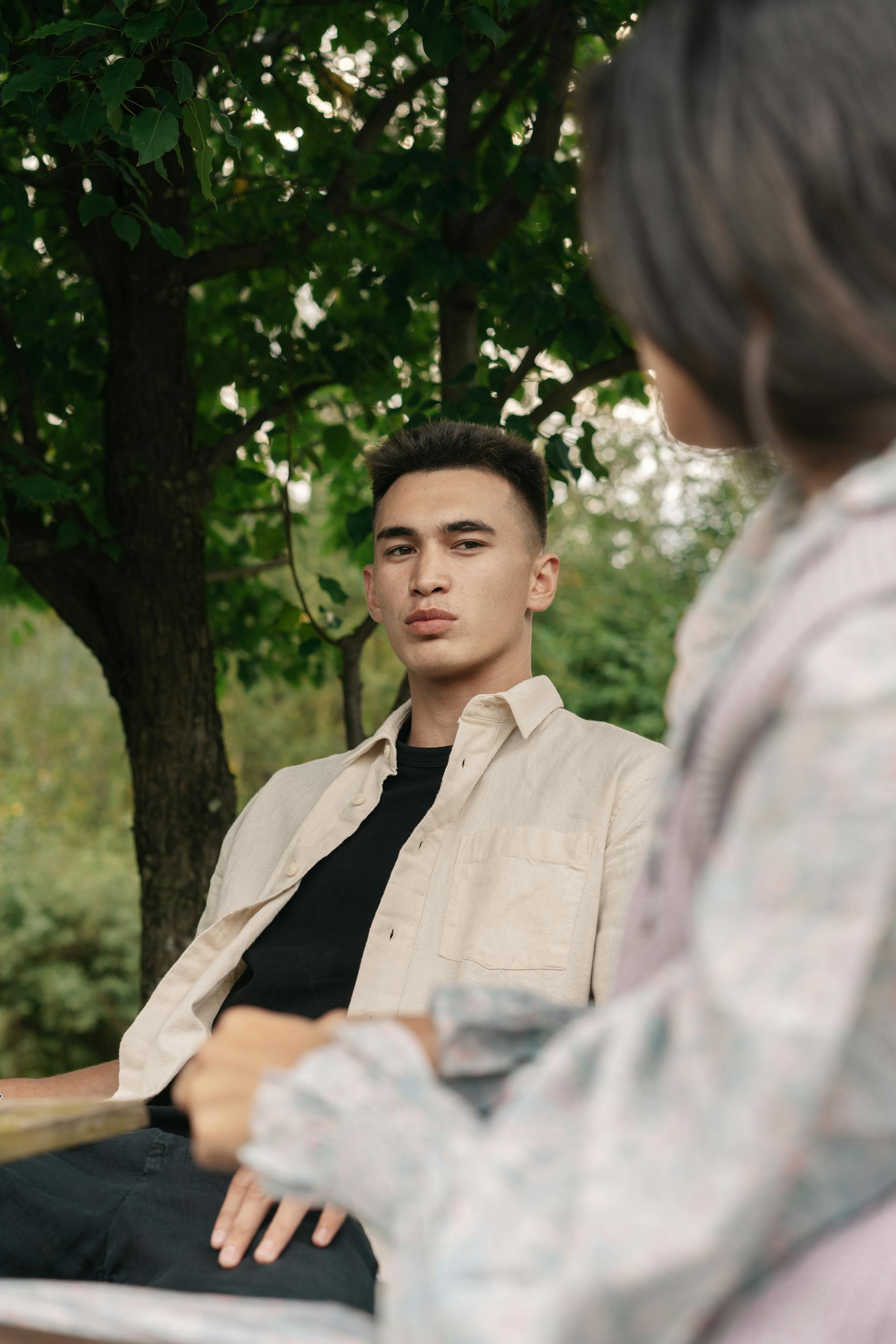 Un hombre preocupado hablando con una mujer sentado al aire libre | Fuente: Pexels