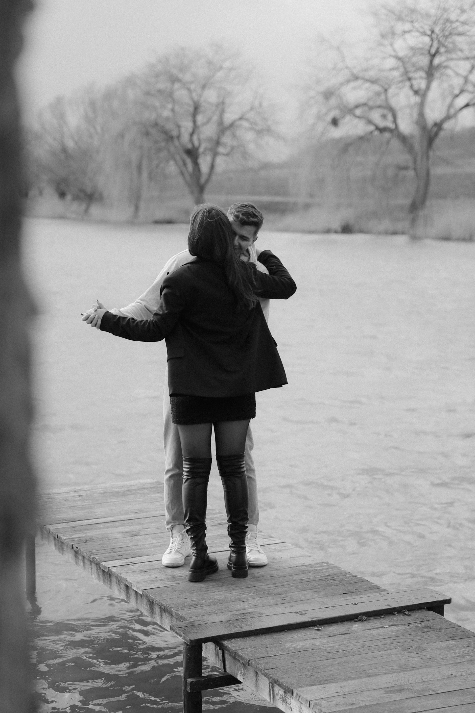 Foto en escala de grises de una pareja bailando en un paseo marítimo | Fuente: Pexels