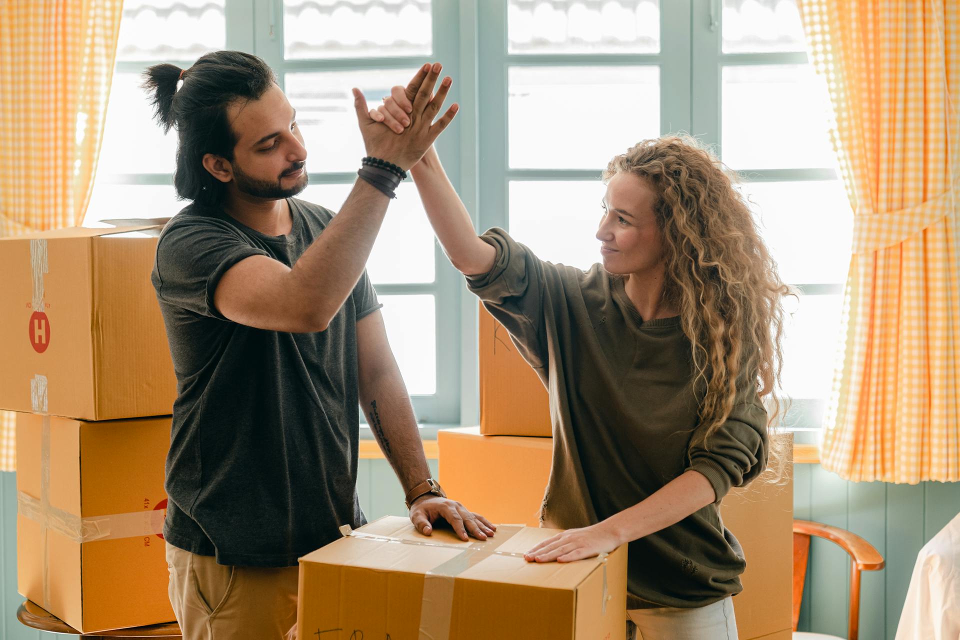 Una pareja desembalando cajas en su nueva casa | Fuente: Pexels