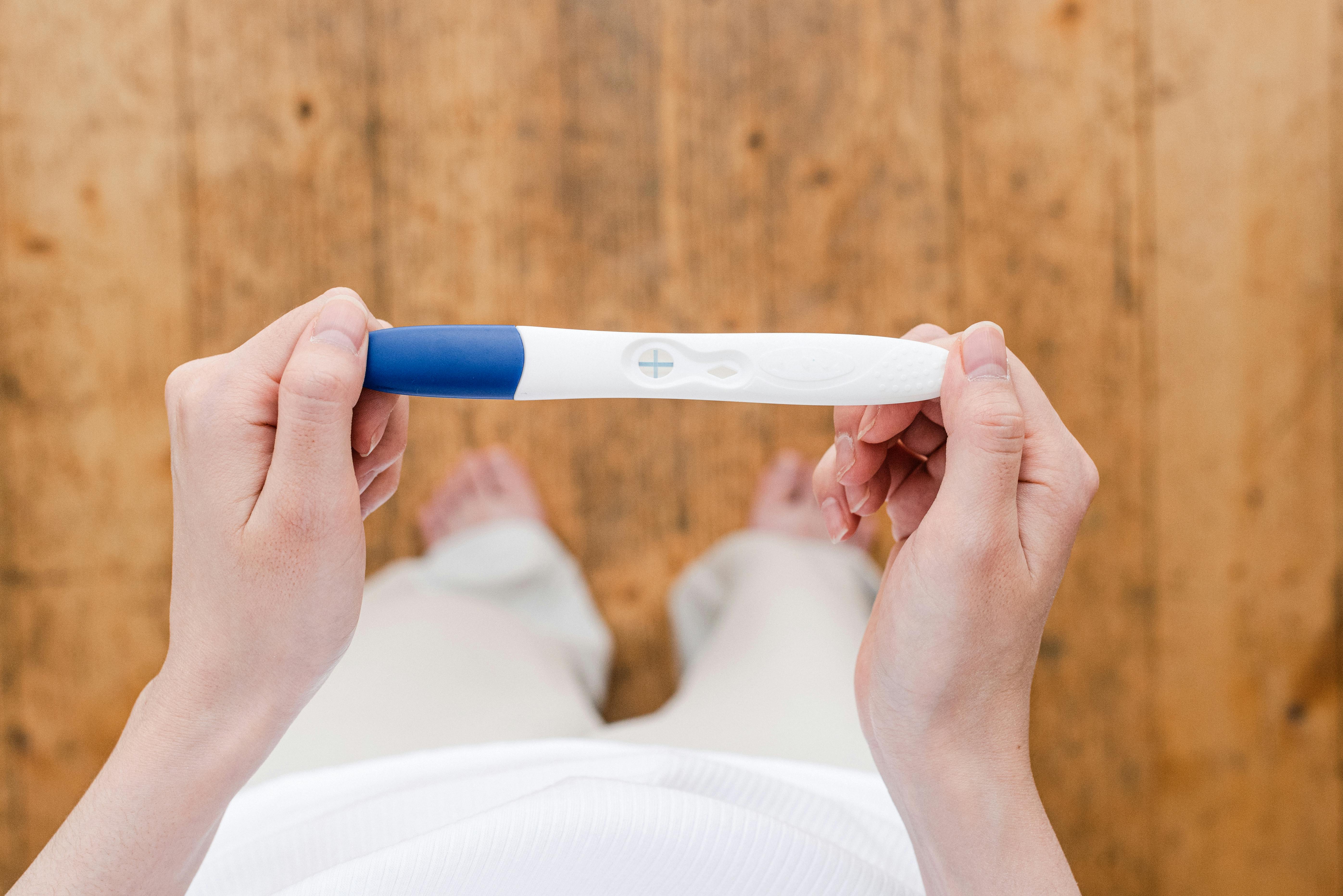 Mujer con un test de embarazo positivo | Foto: Pexels