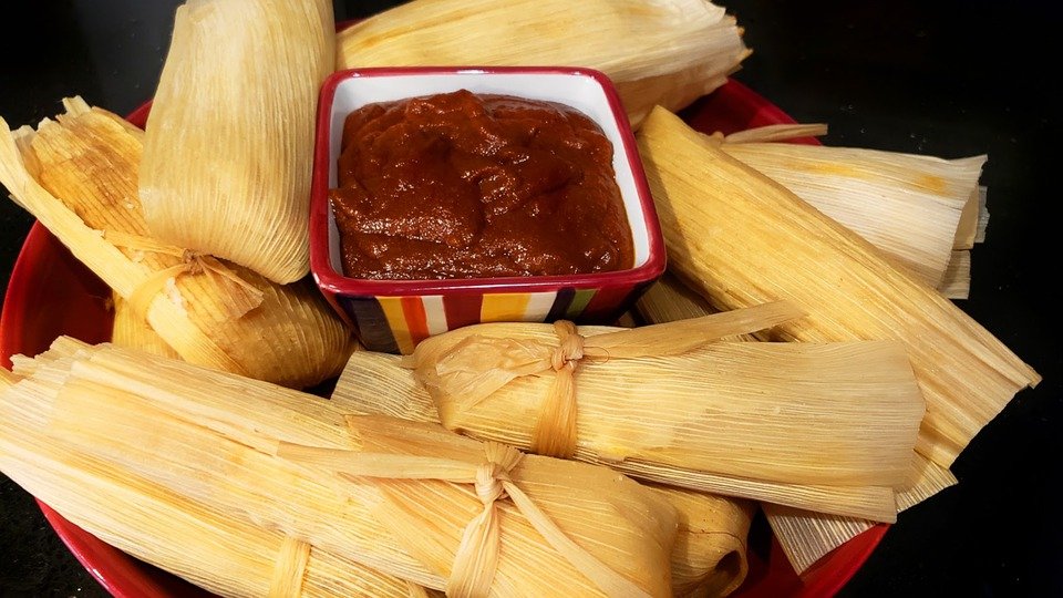Tamales servidos alrededor de una salsa. | Foto: Pixabay
