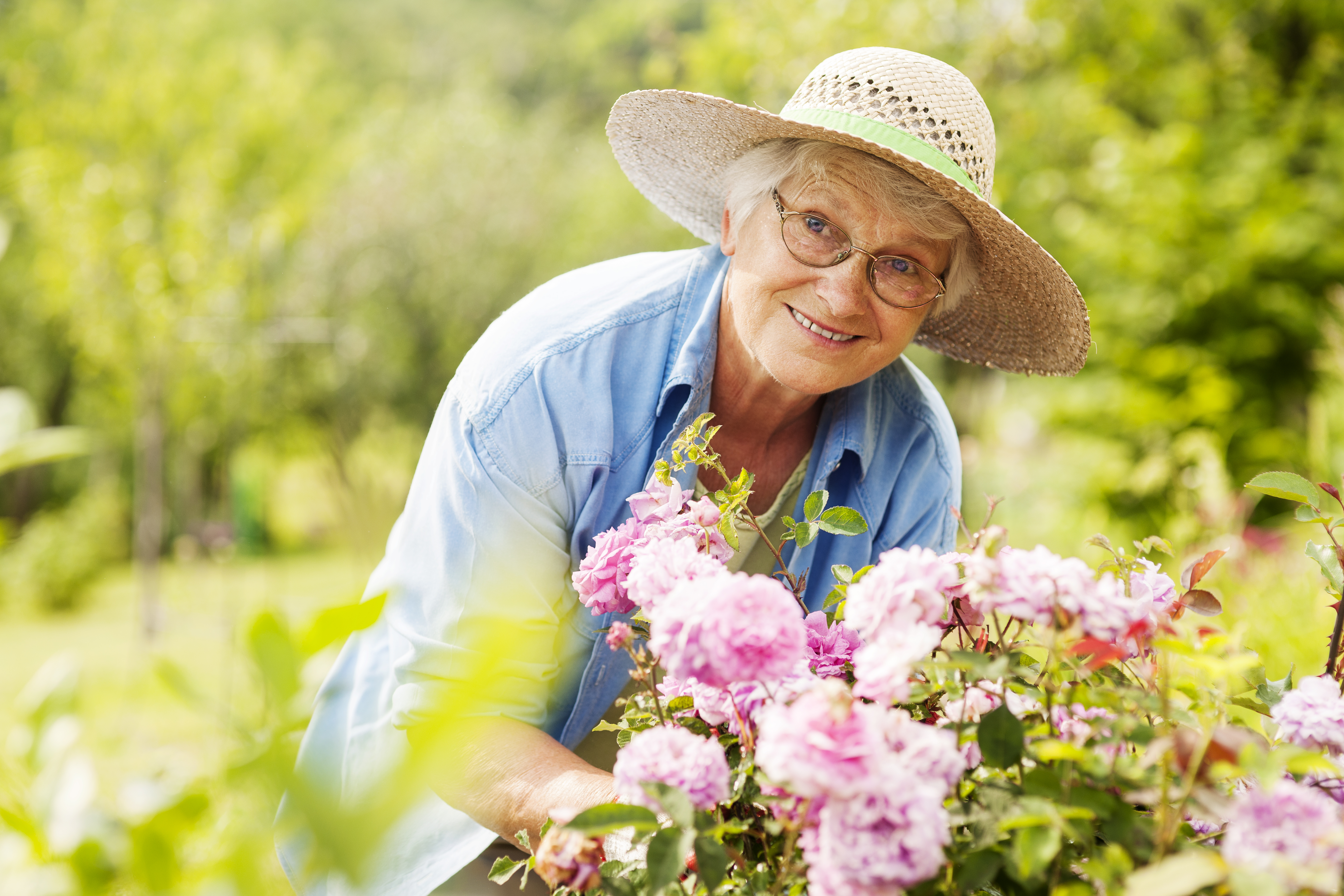 Mujer mayor con flores en el jardín | Foto: Getty Images
