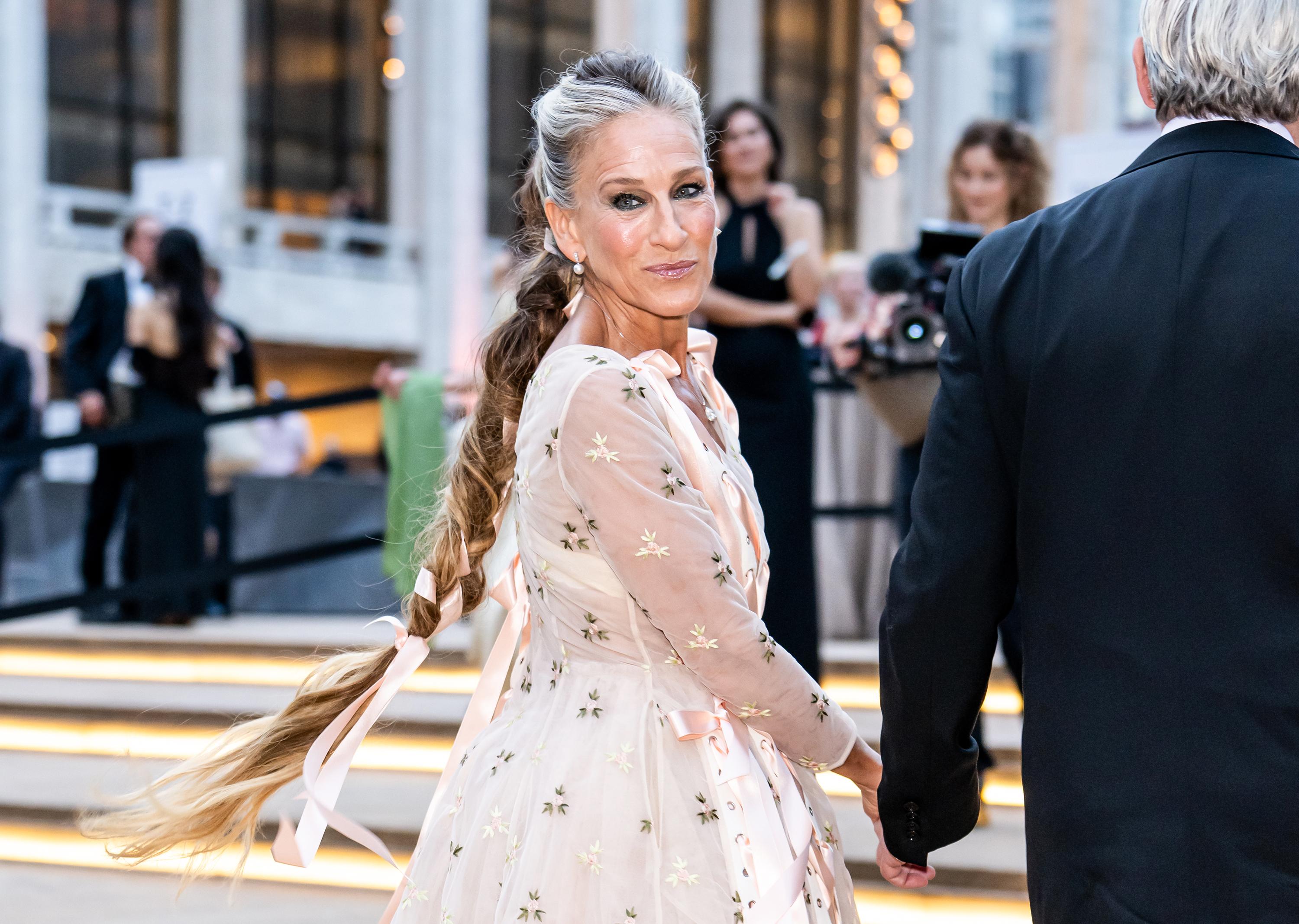 En una foto de perfil se ve la coleta de Parker, adornada con una cinta, cayéndole por la espalda al llegar a la gala de 2026. Su peinado combina tonos plateados en la coronilla con mechones más oscuros en las puntas. | Fuente: Getty Images