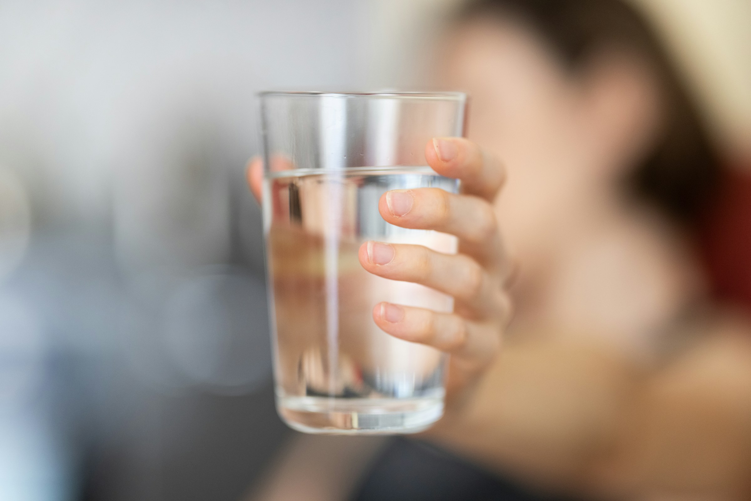 Una persona con un vaso de agua en la mano | Fuente: Unsplash