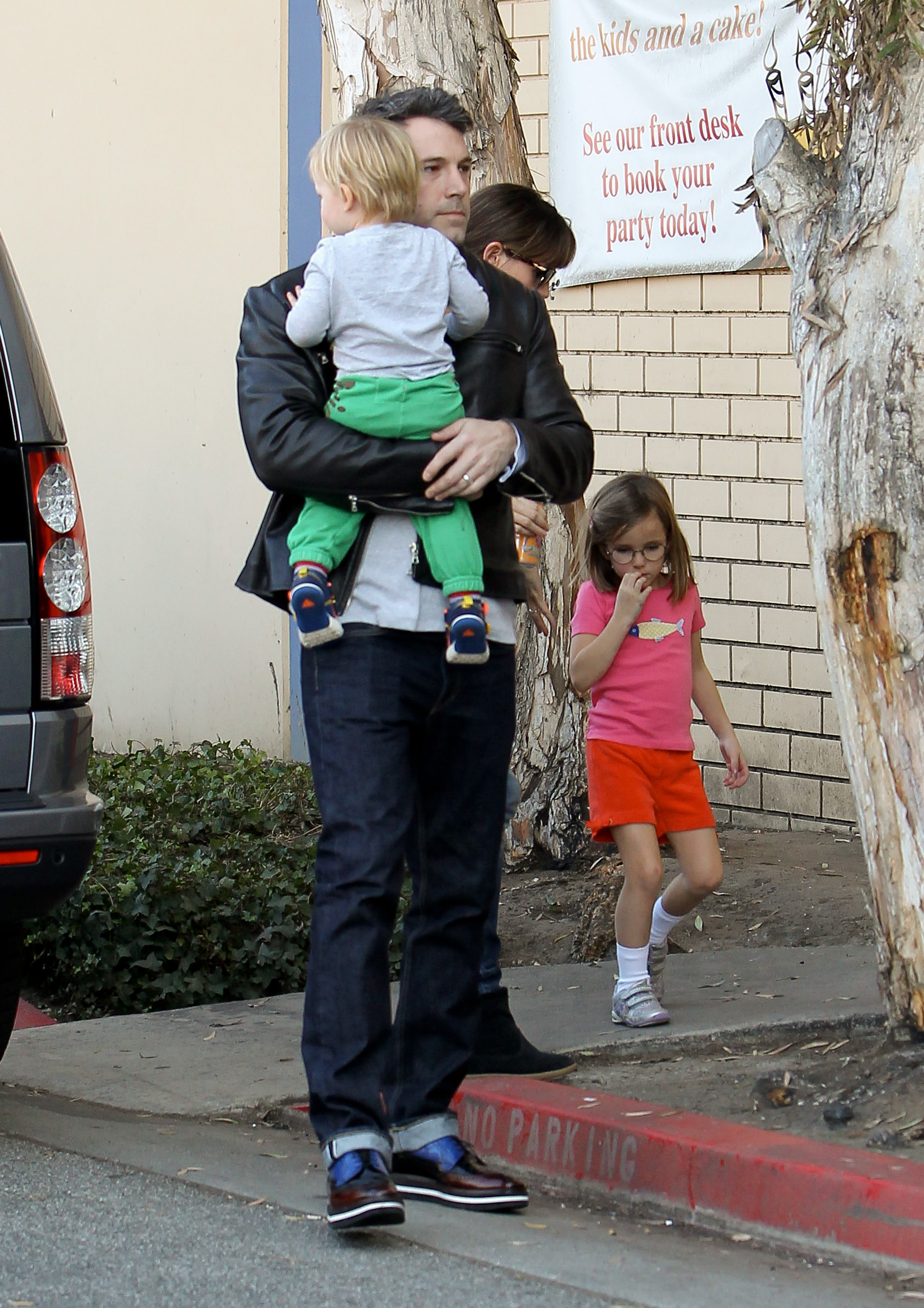 Ben Affleck camina con Samuel Garner Affleck cerca de su pecho mientras Jennifer Garner camina detrás con su hija Seraphina Affleck el 9 de noviembre de 2013, en Los Ángeles, California | Fuente: Getty Images