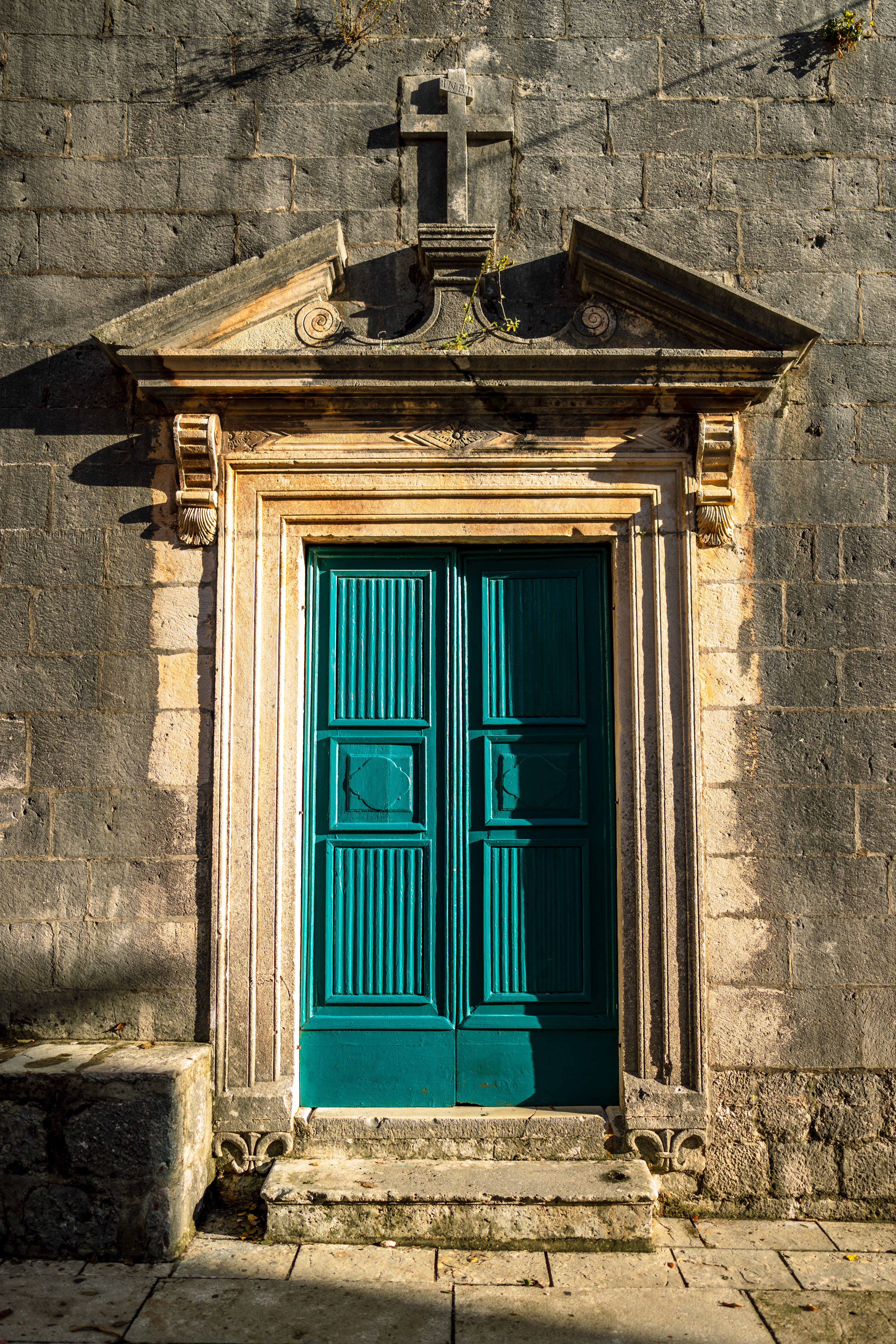 Una puerta azul de madera de un edificio de piedra. | Fuente: Pexels