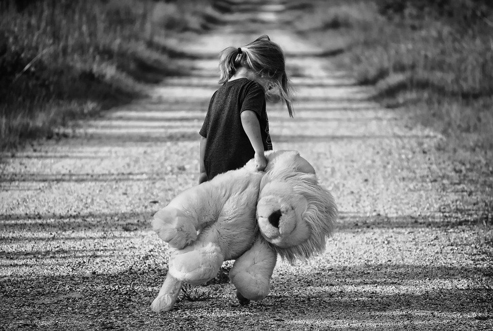 Niña triste caminando con su peluche por una carretera. | Foto: Pixabay