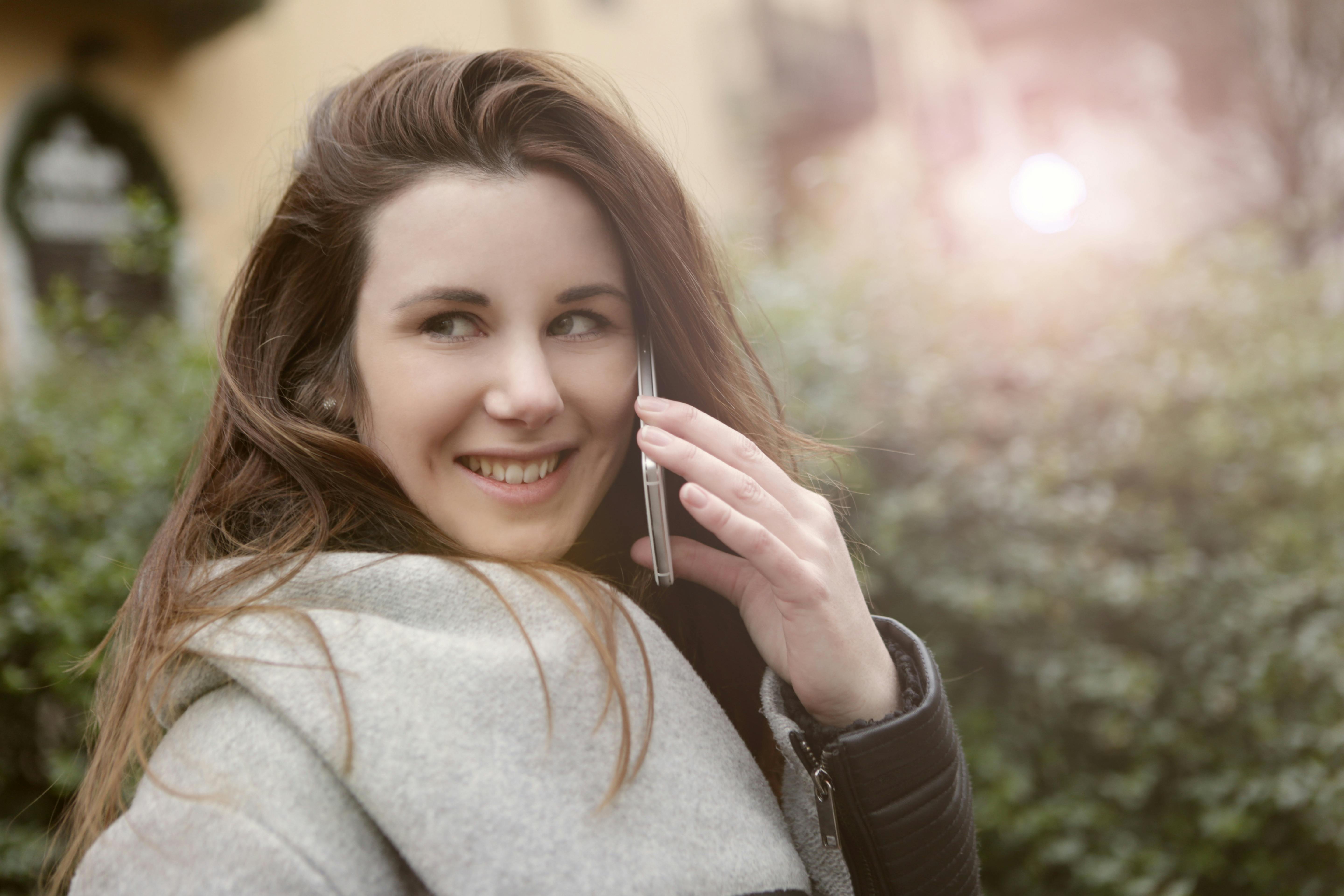 Una mujer feliz hablando por teléfono | Fuente: Pexels