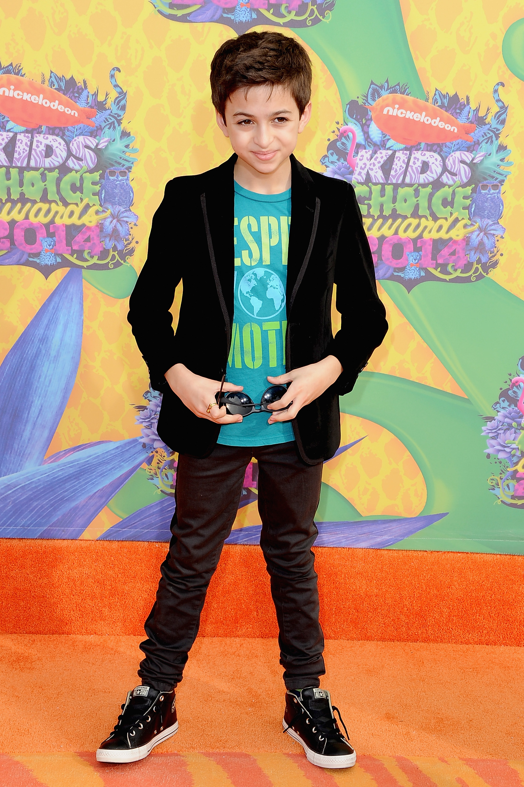 Asiste a la 27ª edición de los Kids' Choice Awards de Nickelodeon en Los Ángeles, California, vestida con una chaqueta negra, una camiseta estampada de color turquesa, pantalones oscuros y zapatillas de caña alta. | Fuente: Getty Images