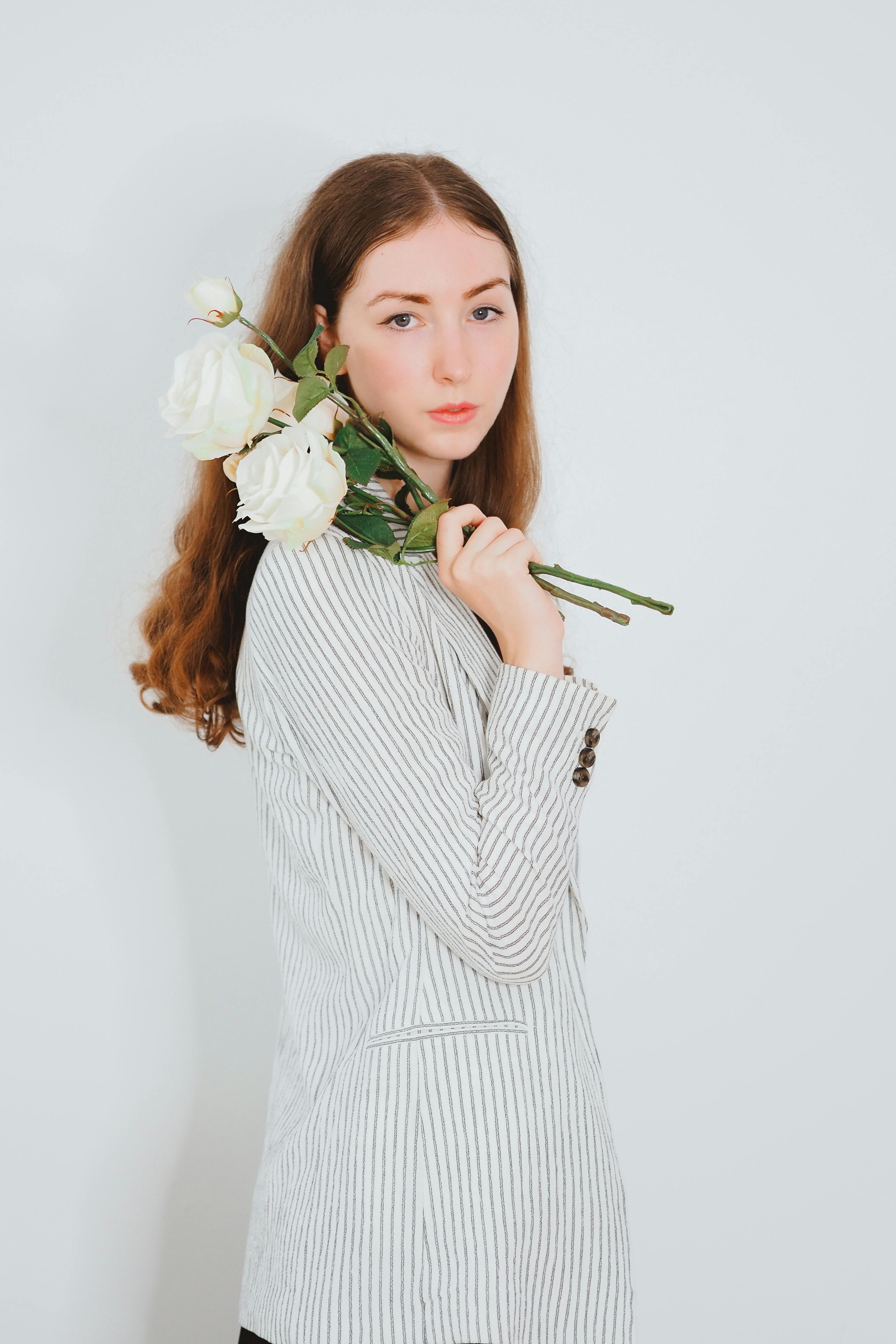 Una mujer sosteniendo rosas blancas | Fuente: Pexels