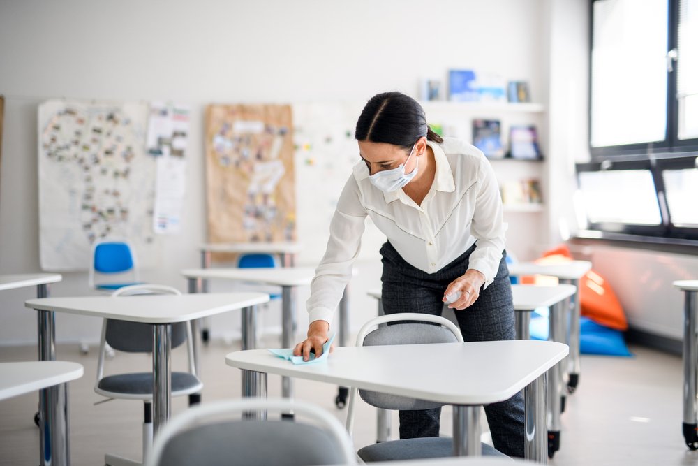 Maestra limpiando aula de clases. | Foto: Shutterstock.