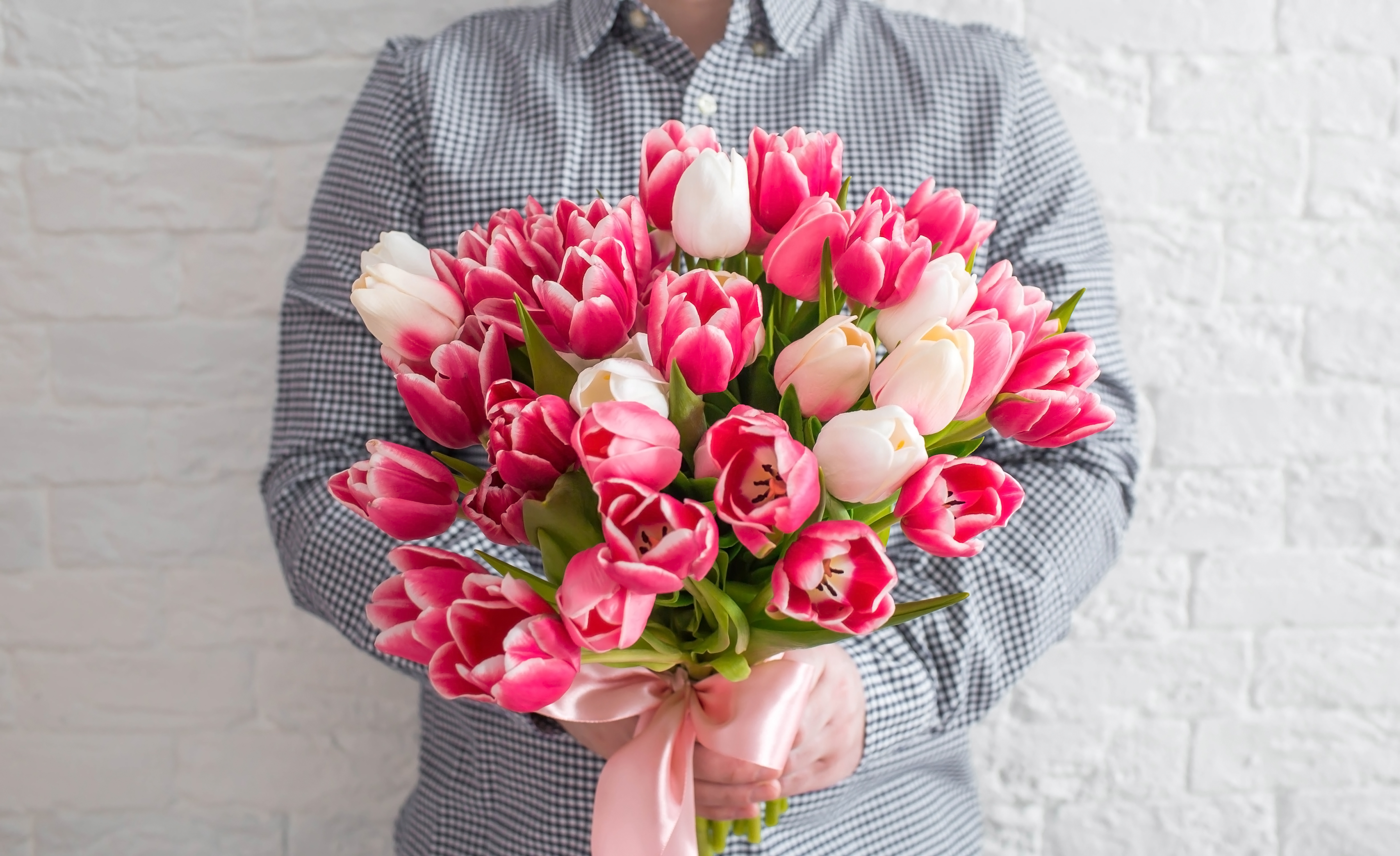 Hombre con un ramo de tulipanes blancos y rosas | Foto: Shutterstock