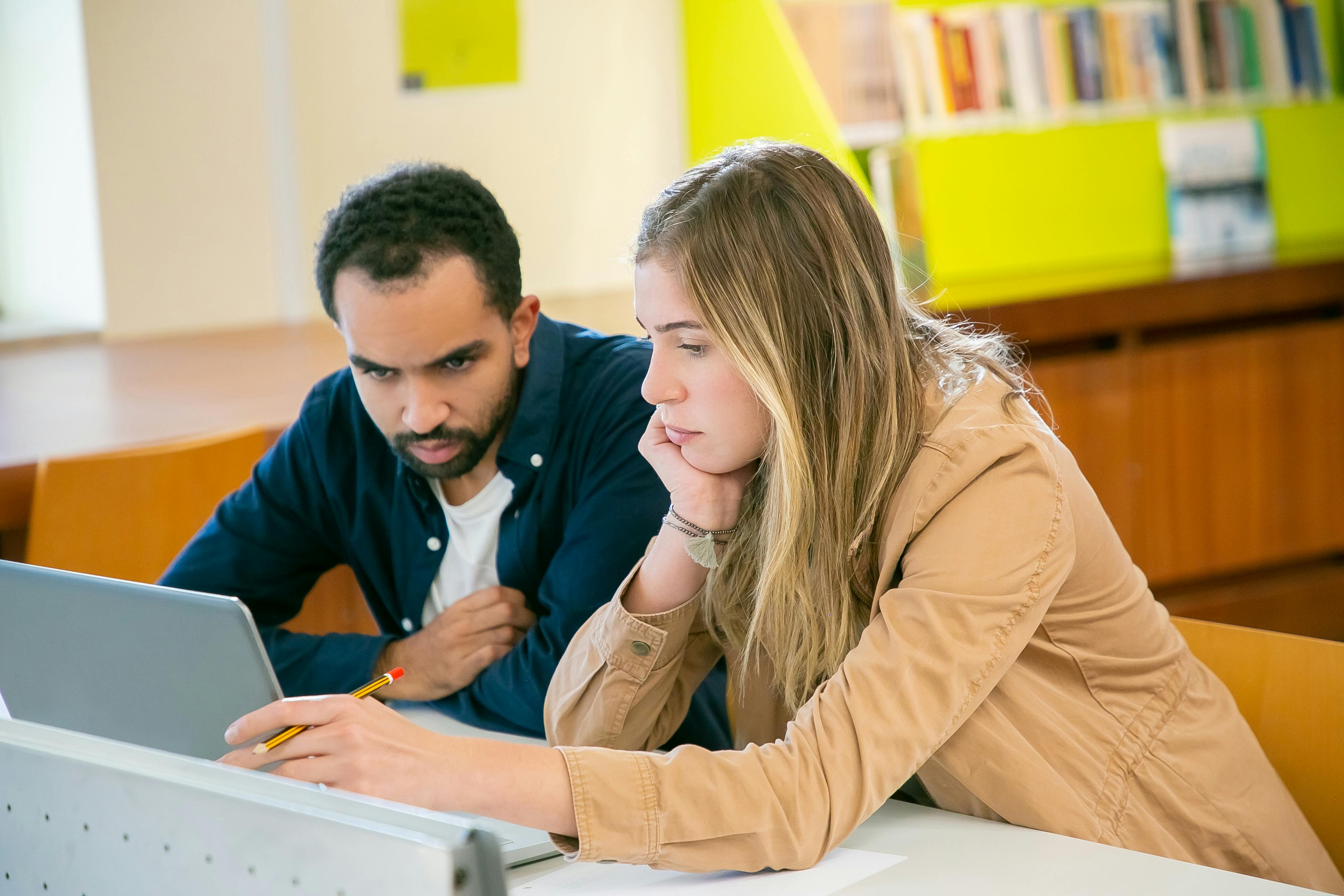 Una pareja infeliz utilizando juntos un ordenador portátil | Fuente: Pexels