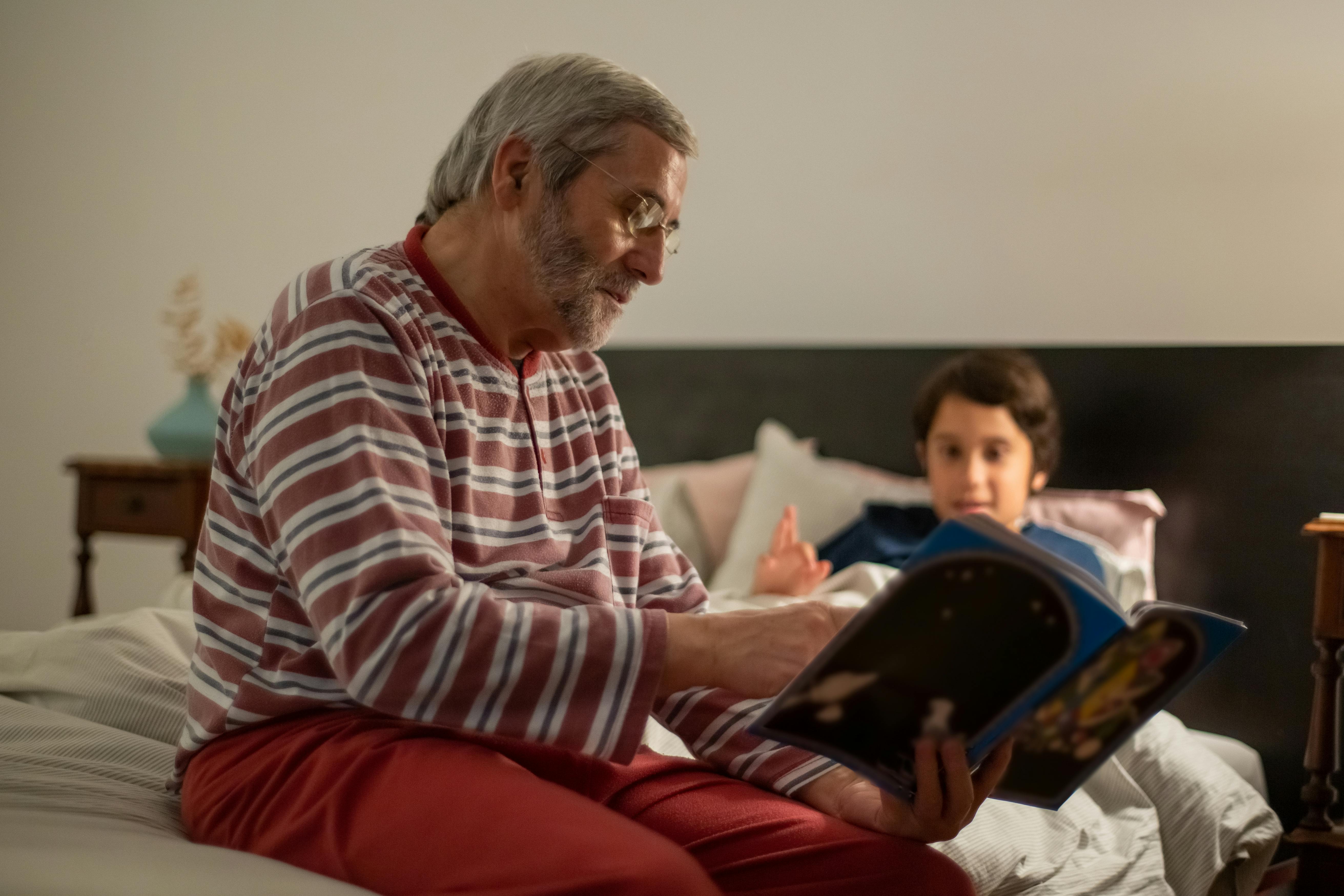 Un uomo che legge un libro a un bambino | Fonte: Pexels