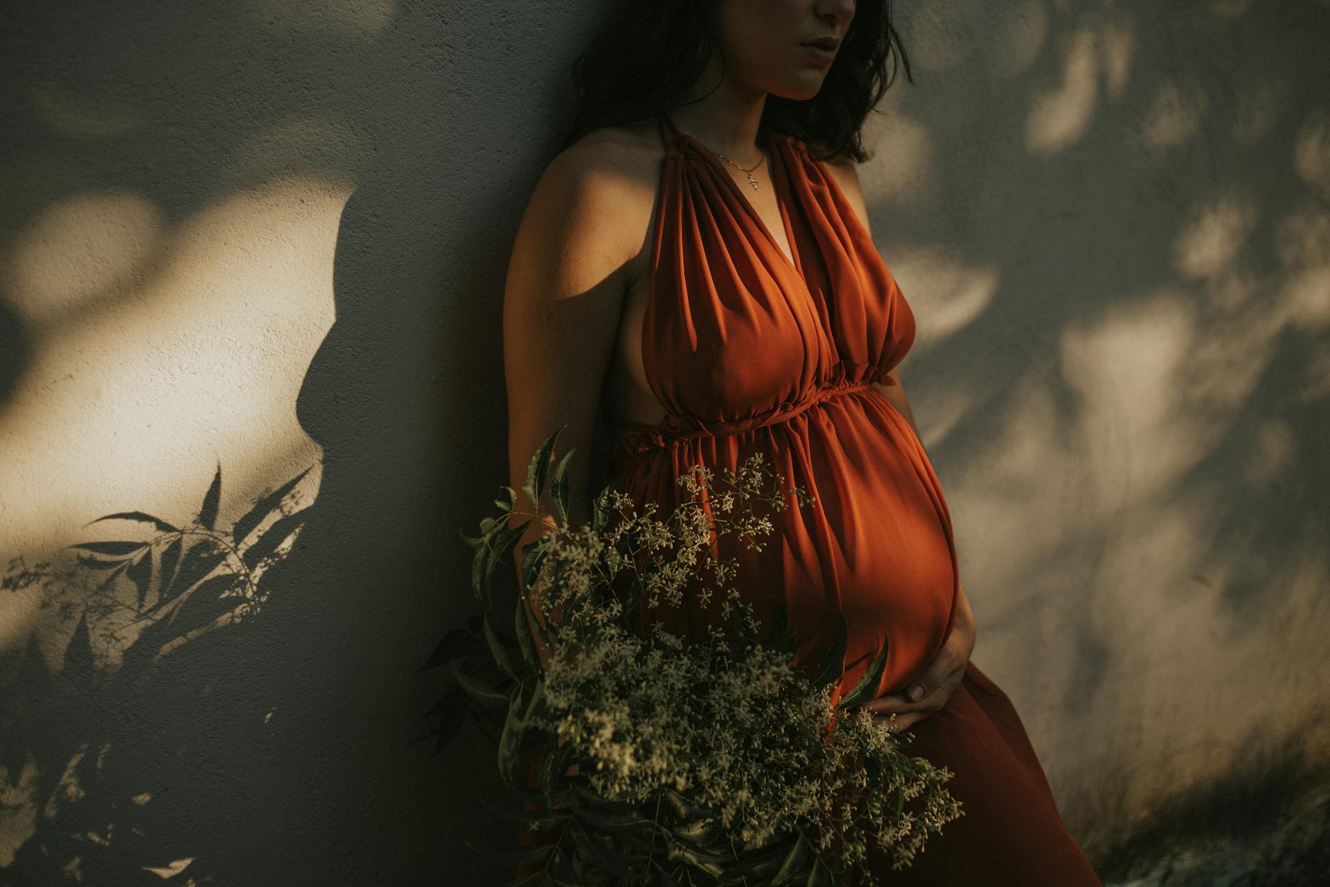 Mujer embarazada contra una pared | Foto: Pexels