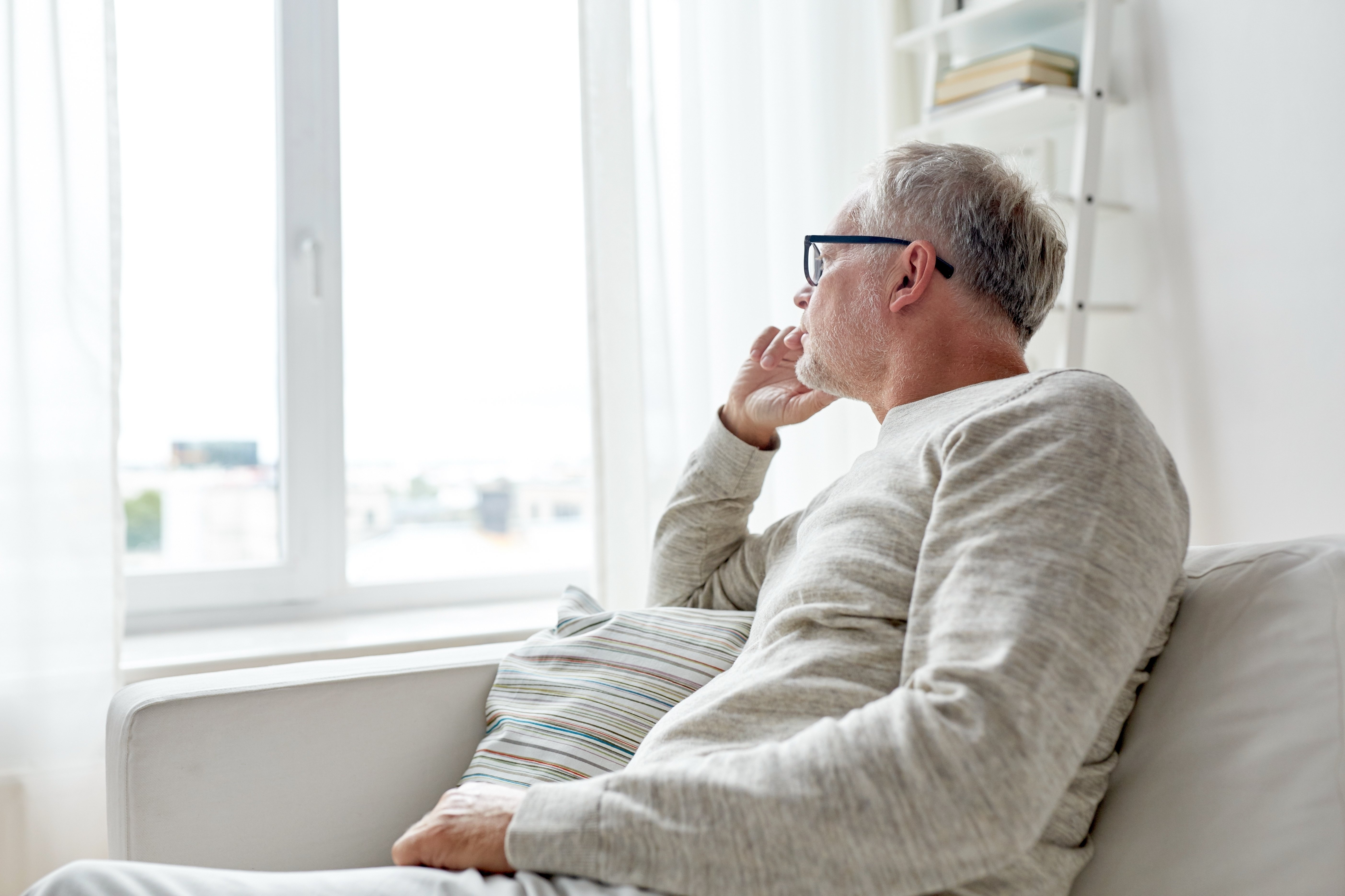 Hombre mayor pensativo mirando hacia la ventana. | Foto: Shutterstock