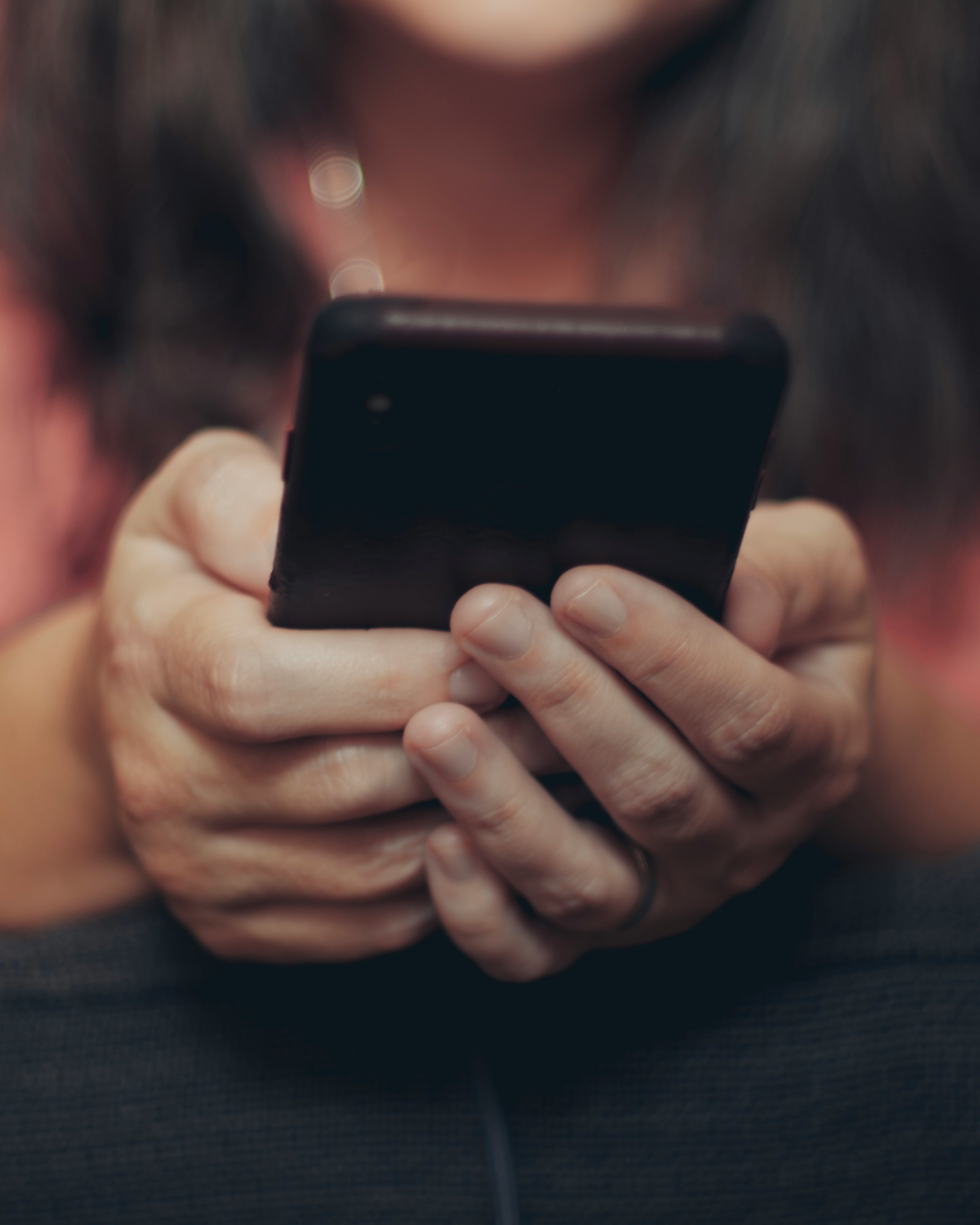 Un par de manos sujetando un teléfono móvil | Fuente: Unsplash