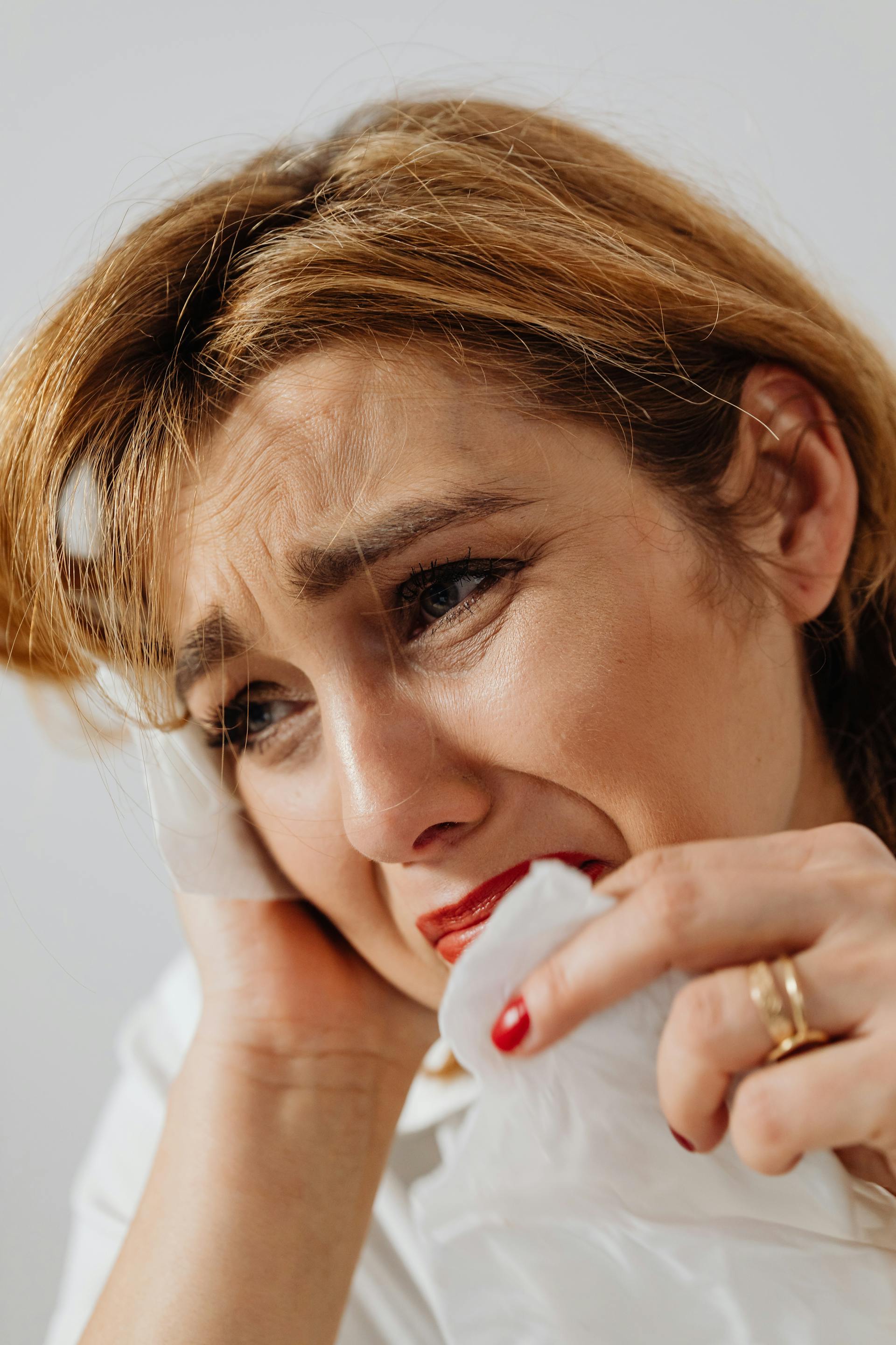 Una mujer con el corazón roto secándose las lágrimas | Fuente: Pexels