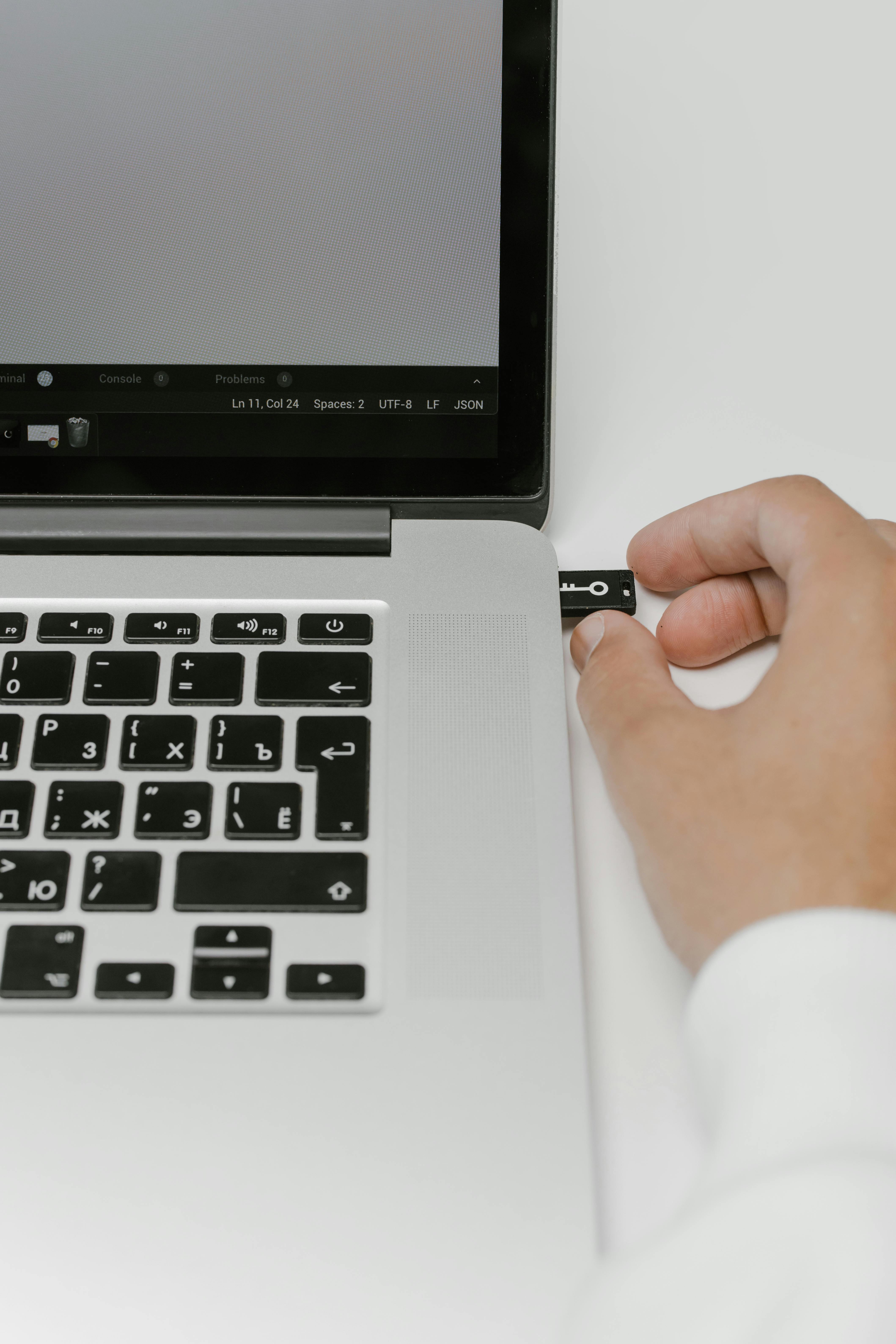 Un hombre introduce una memoria USB | Fuente: Pexels