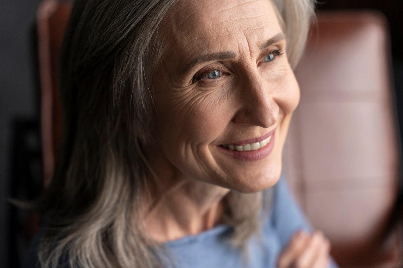 Una anciana sonriente mirando a su lado | Fuente: Freepik