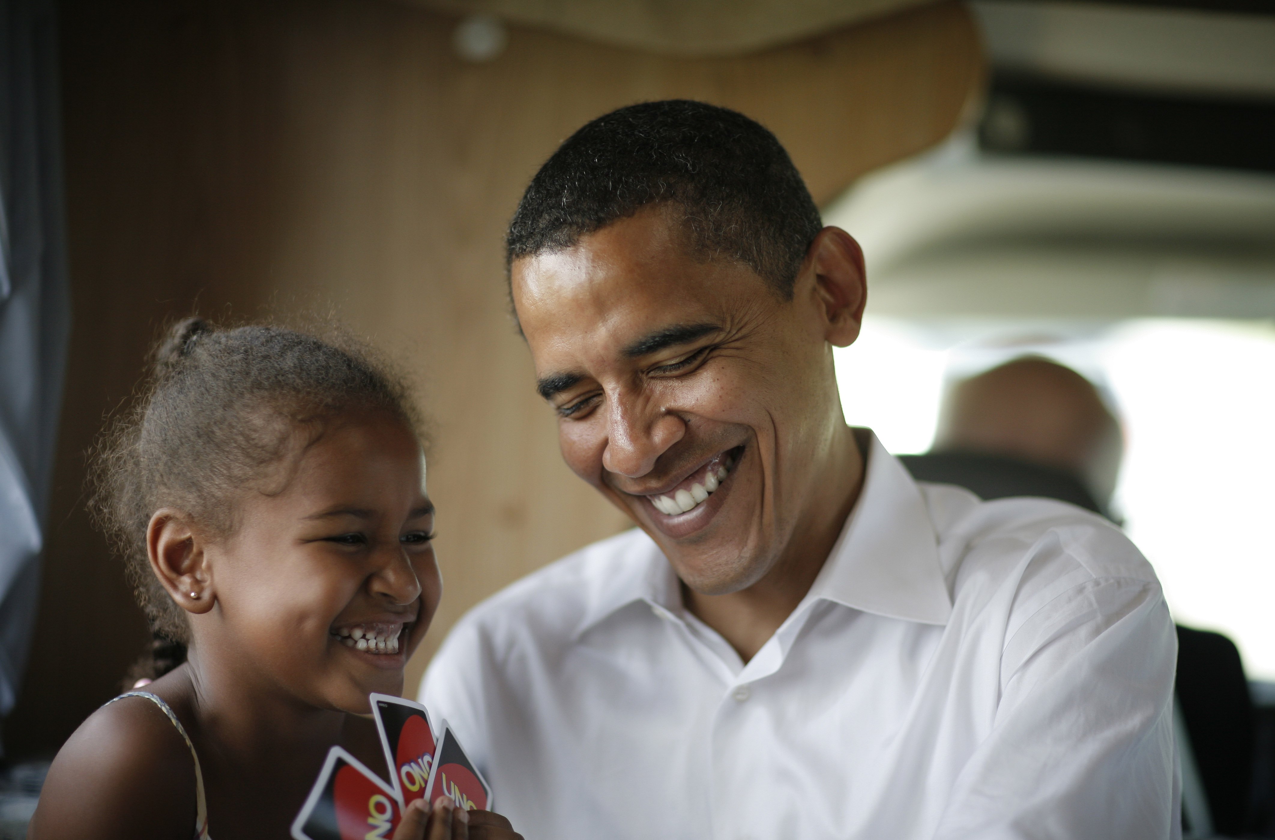 Sasha y Barack Obama juegan a las cartas en su autocaravana mientras hacen campaña entre Oskaloosa y Pella, Iowa, el 4 de julio de 2007 | Fuente: Getty Images