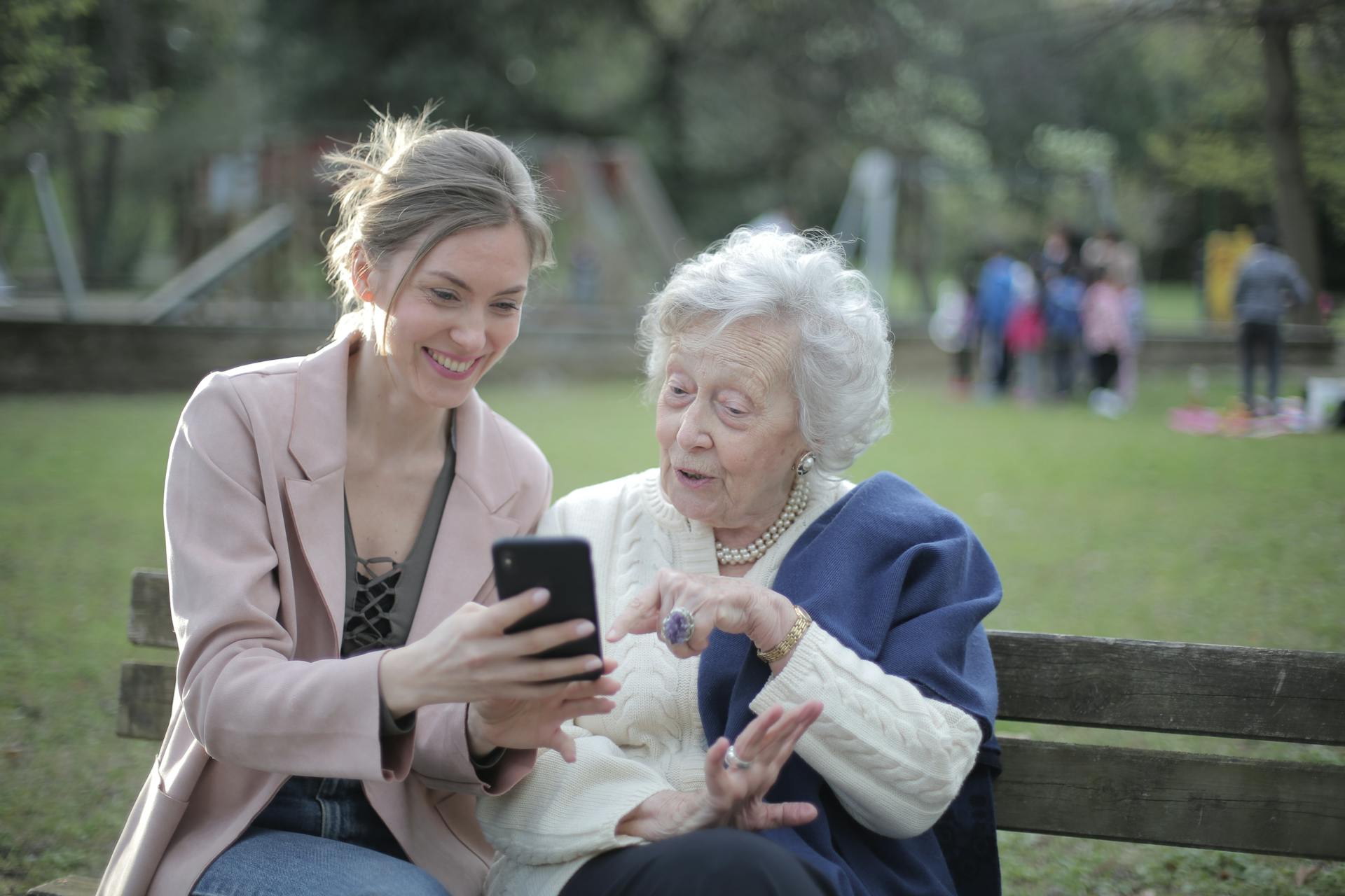 Una mujer muestra algo a una anciana en un smartphone | Fuente: Pexels